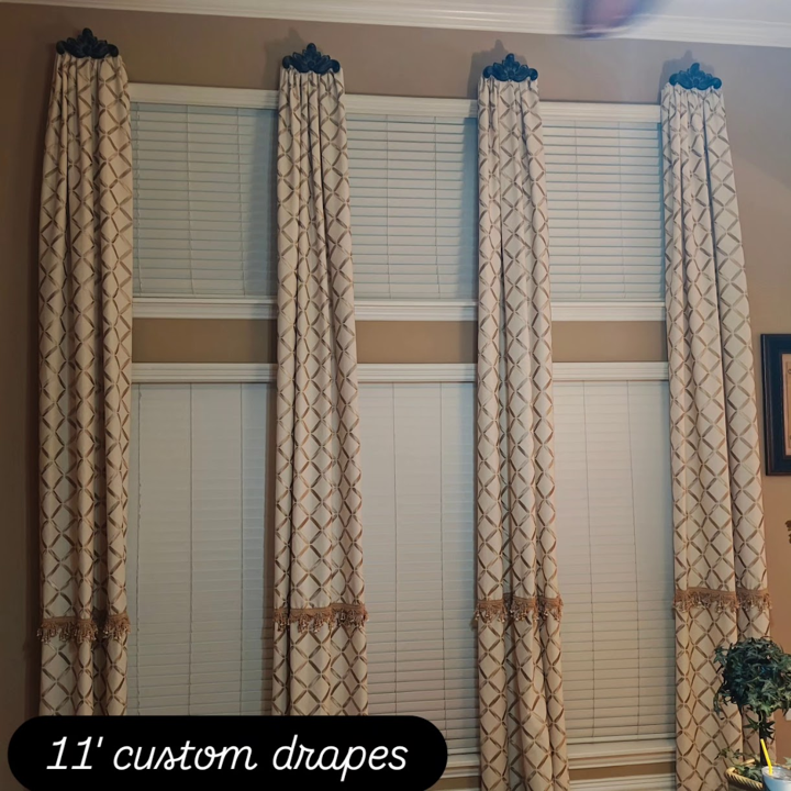 Four windows with 11-inch custom drapes featuring geometric patterns, topped with decorative black curtain rods, in a room with beige walls.