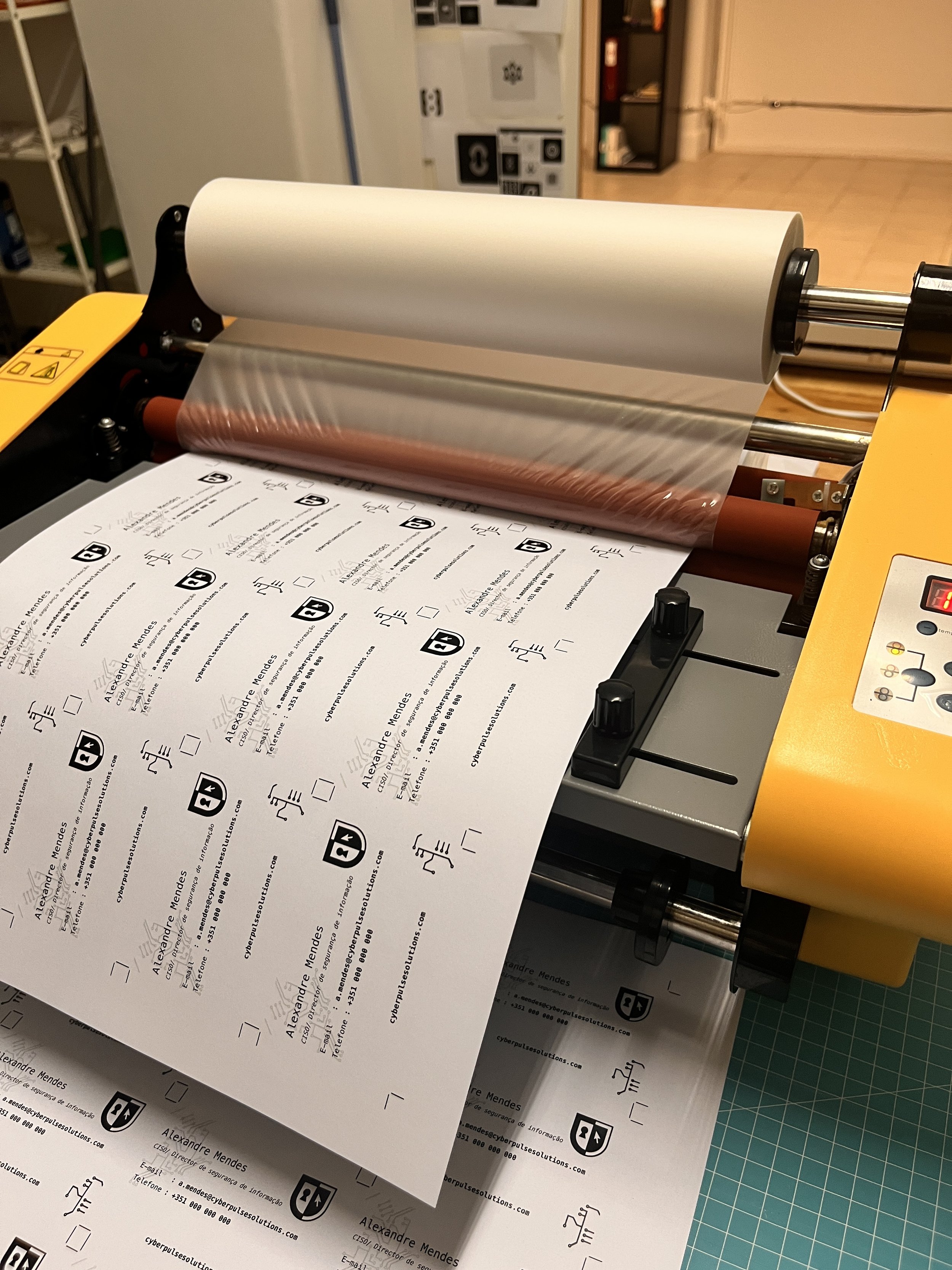 Uma impressora de papel que está alimentando uma folha cheia de ícones e textos em português.