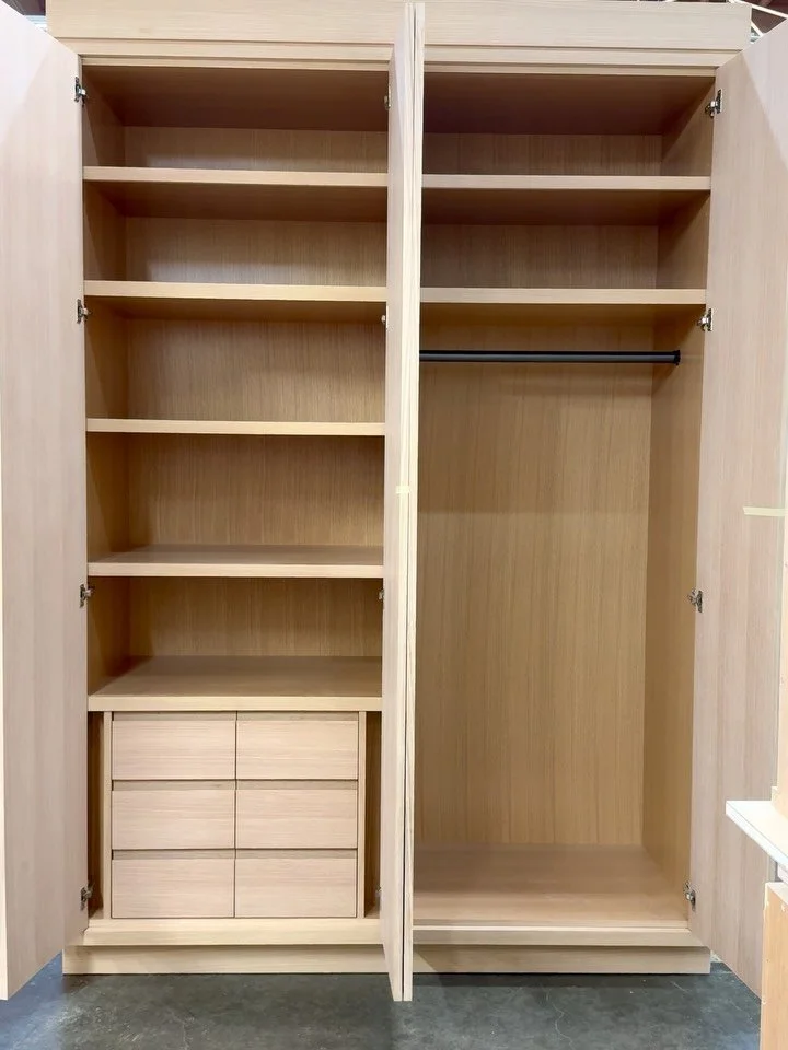 Designed as a complete storage solution for a Guest bedroom, this custom rift white oak cabinet features spacious adjustable shelving, concealed storage drawers with integrated finger pulls, and a dedicated hanging section with a closet pole&mdash;br