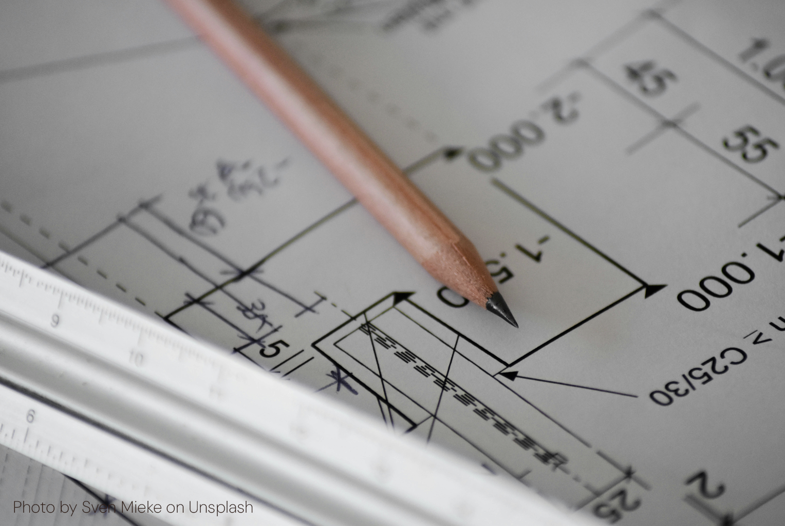 Close-up of a dimensioned engineering detail drawing specifying a C25/30 concrete grade, with a pencil and scale rule across it.