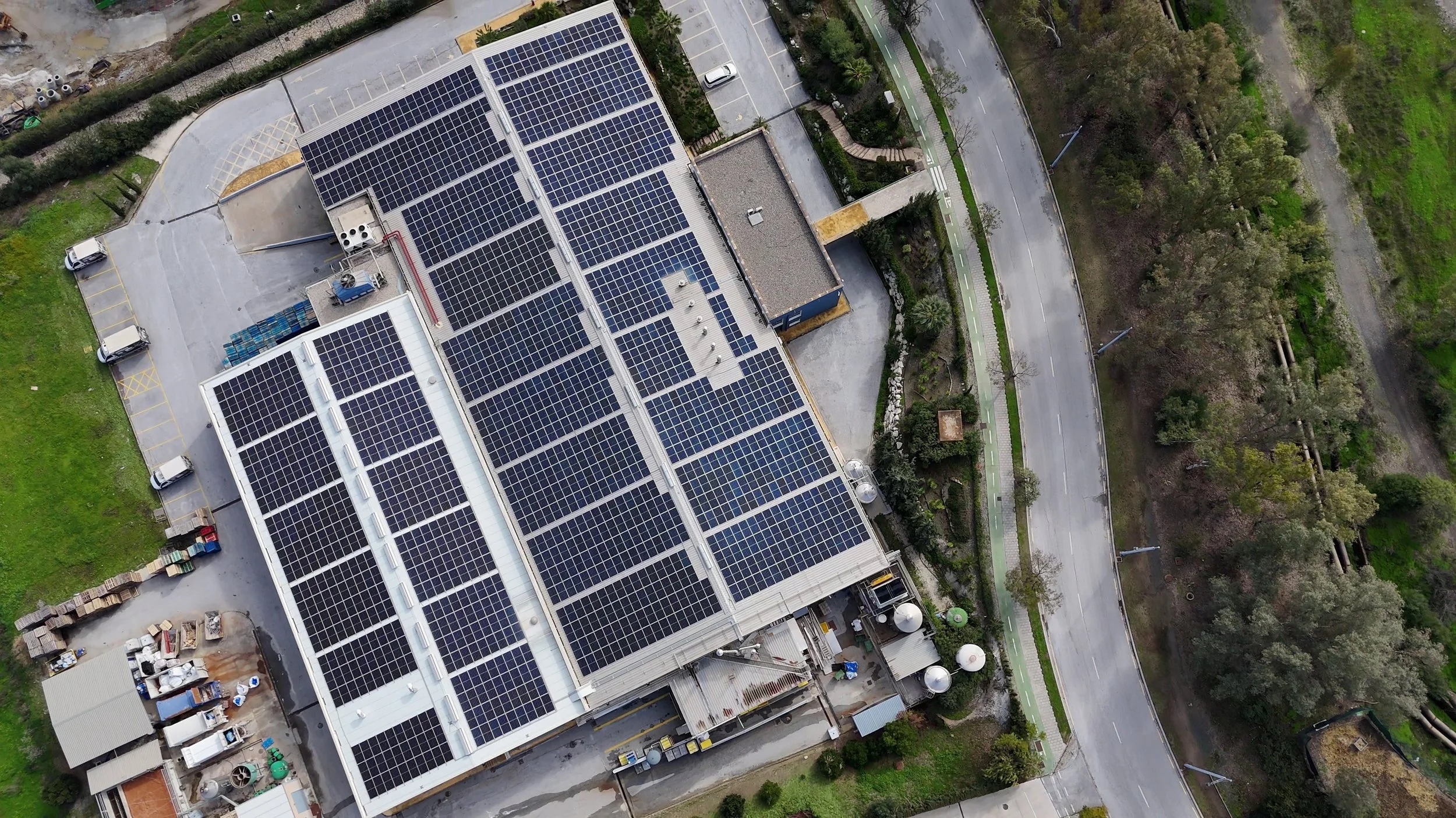 Aerial view of an industrial facility with a full rooftop solar array — a capital asset built with sustainability designed in.
