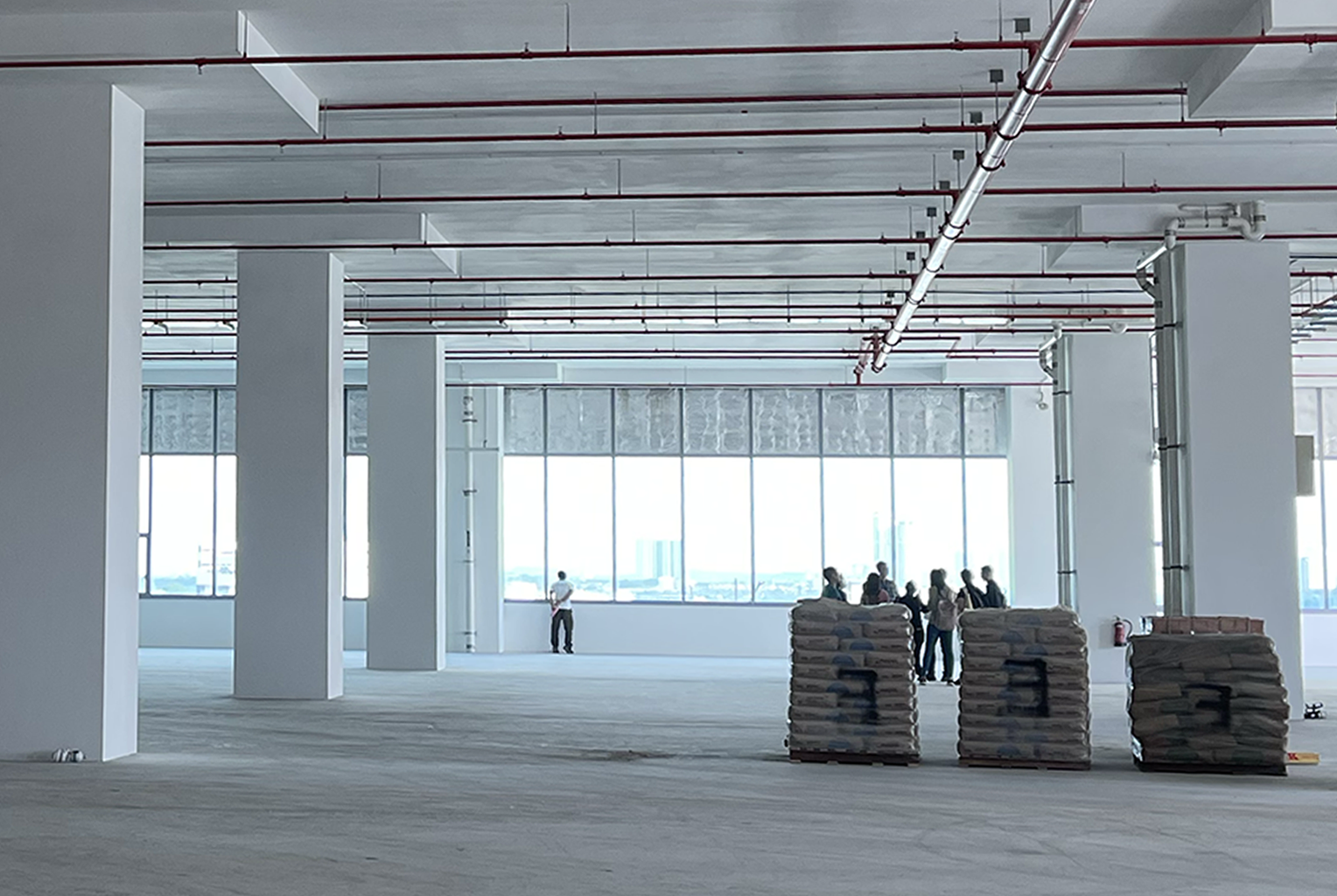 Business team inspecting a bare shell office floor with exposed services before committing to the space