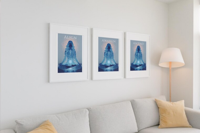 Three motivational art prints with a meditative figure in blue tones, each with words "Align," "Awaken," and "Ascend," hanging above a white sofa with beige pillows, in a bright living room.