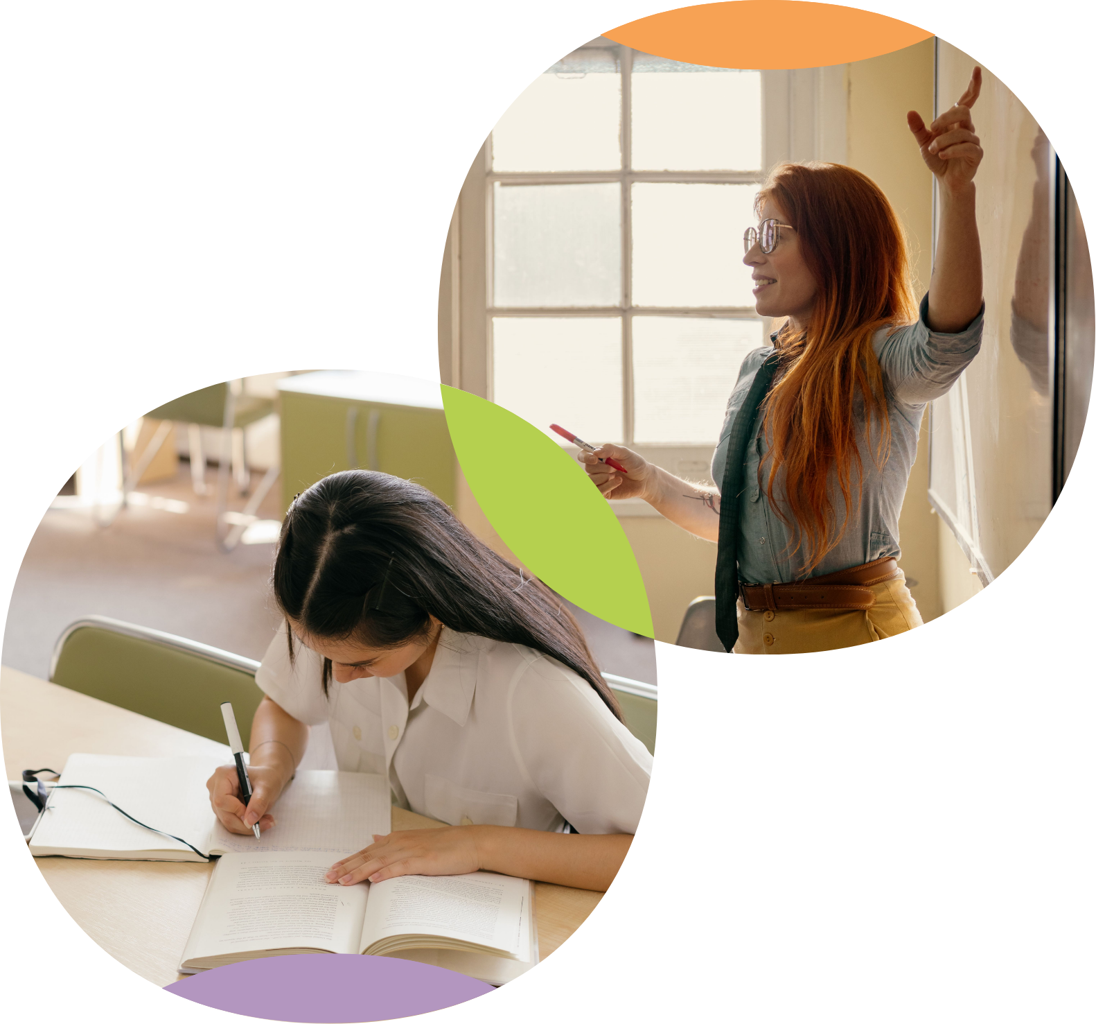 A woman with red hair and glasses is smiling and pointing at a whiteboard with a marker, while another woman is writing notes at a table in a classroom with large windows in the background.