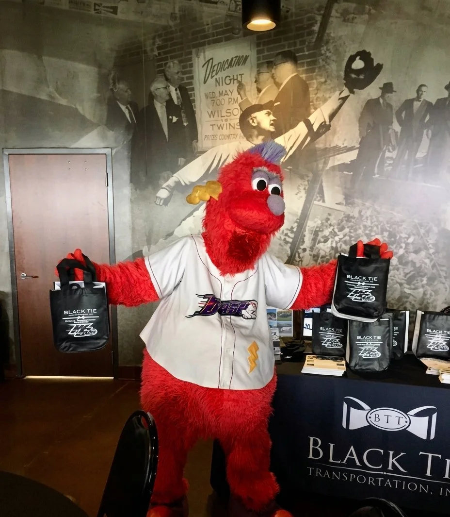 Bolt, the Winston-Salem Dash baseball team mascot, holding black tie transportation inc. merchandise
