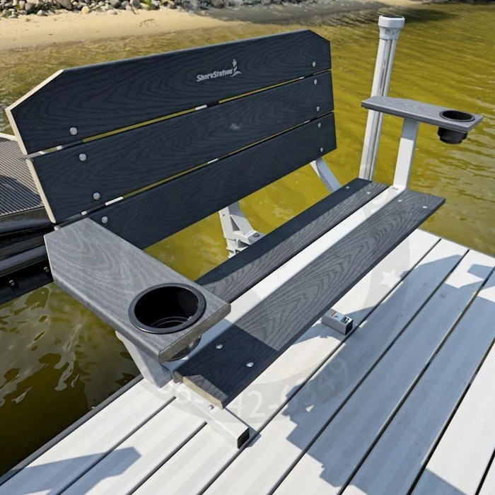 A lakeside bench with built-in cup holders, mounted on a dock, overlooking calm water.