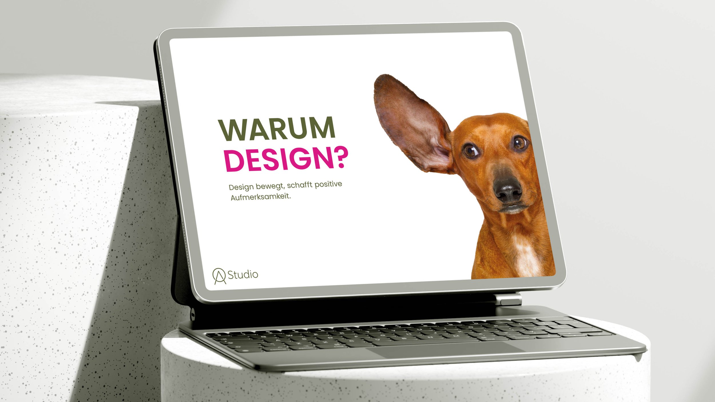 Tablet zeigt Präsentationsfolie "Warum Design?" mit einem Hund, dessen Ohr ins Bild ragt