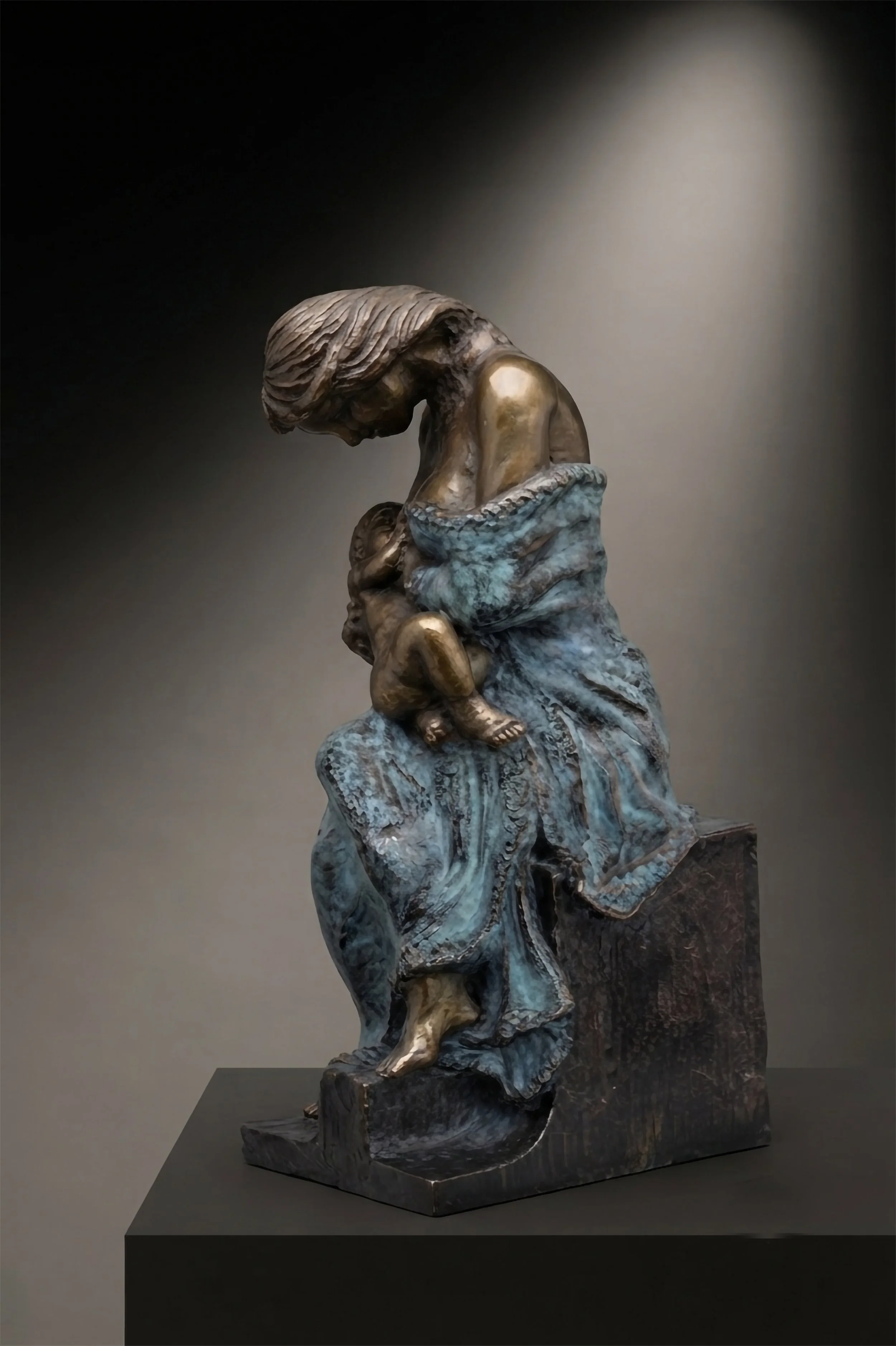 Vista de perfil de 'Maternidad', escultura de bronce de Raúl Abad. Obra realizada mediante fundición a la cera perdida, un proceso artesanal que garantiza la fidelidad al modelo en barro original."