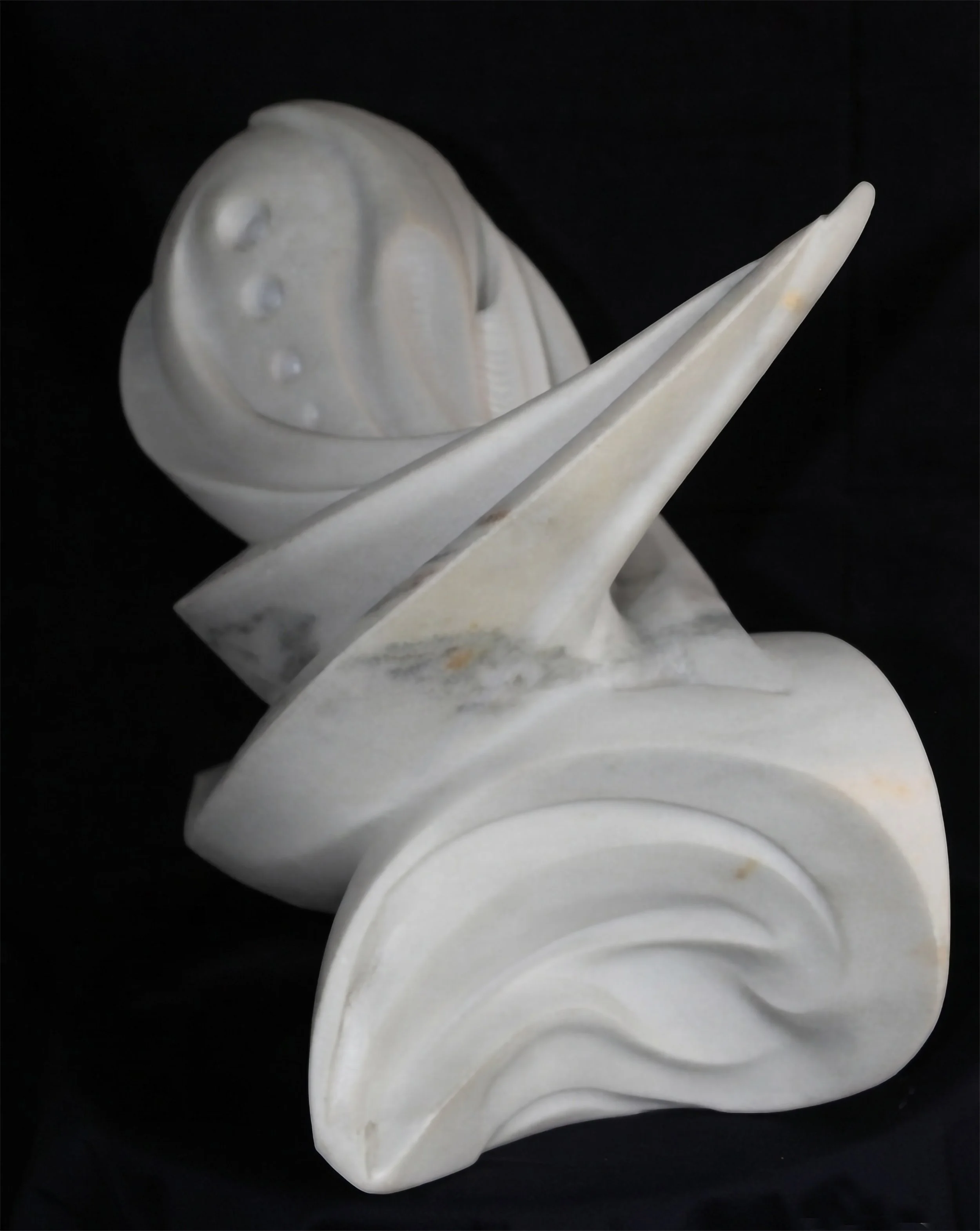 Ángulo detallado de la escultura 'Ondas', obra del escultor Raúl Abad. Escultura de mármol blanco tallada a mano, ideal para colecciones de arte contemporáneo.