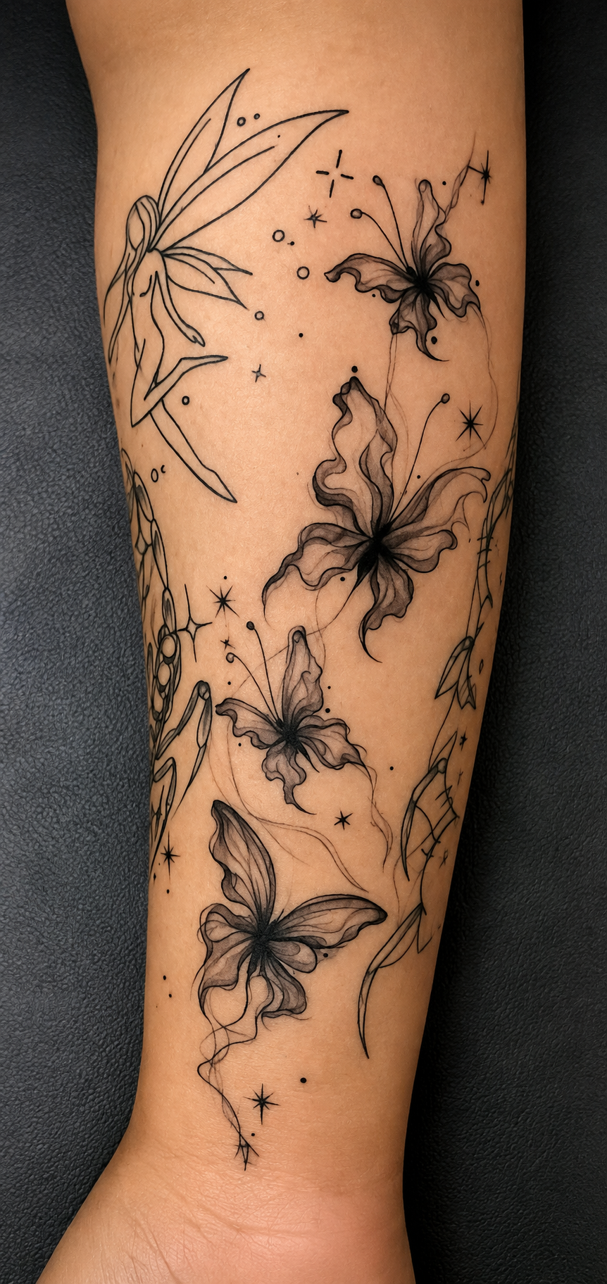 Tattoo of four butterflies with detailed wings, surrounded by stars, dots, and floral elements on a person's arm.