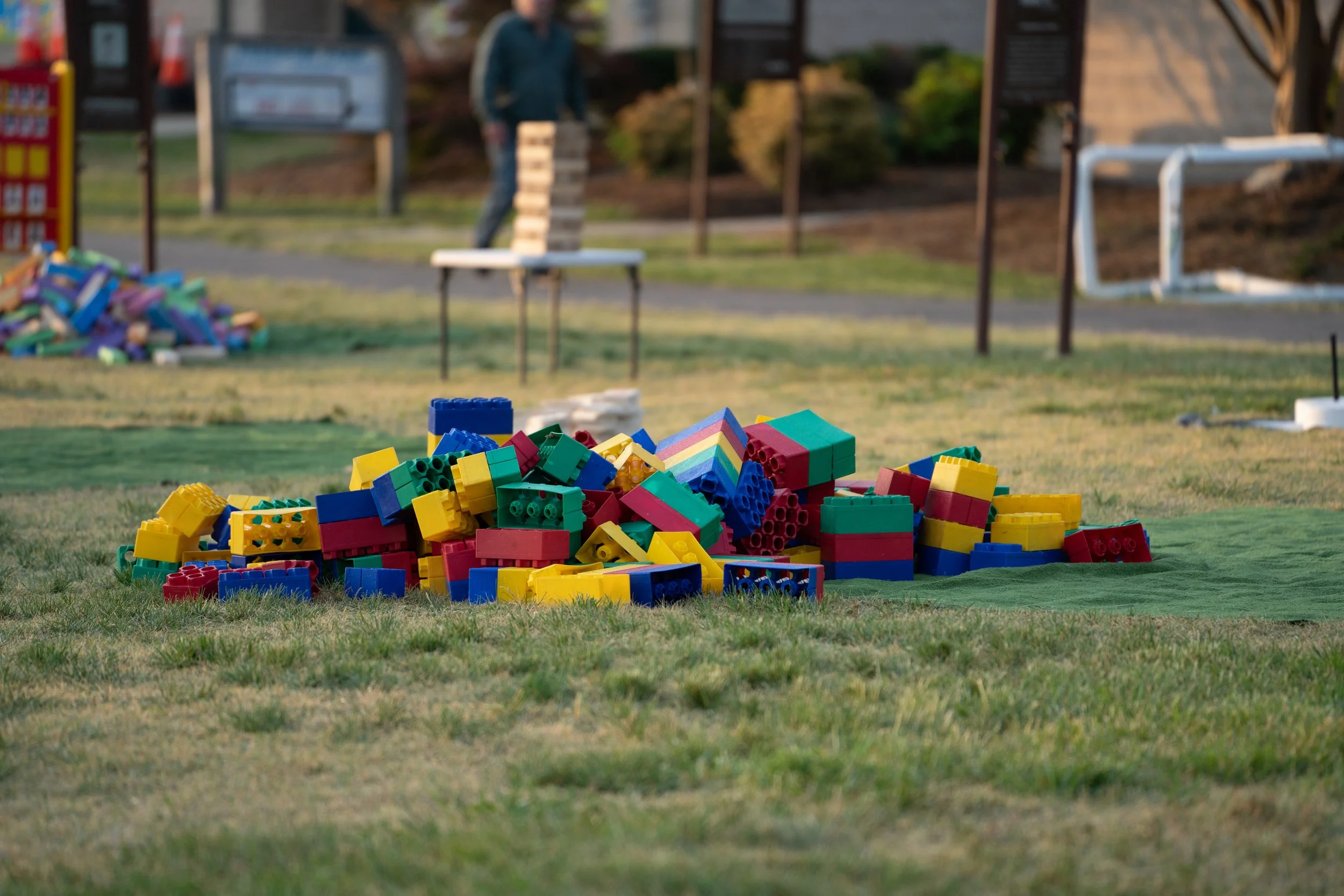 Colorful building blocks scattered on a grassy area in a playground
