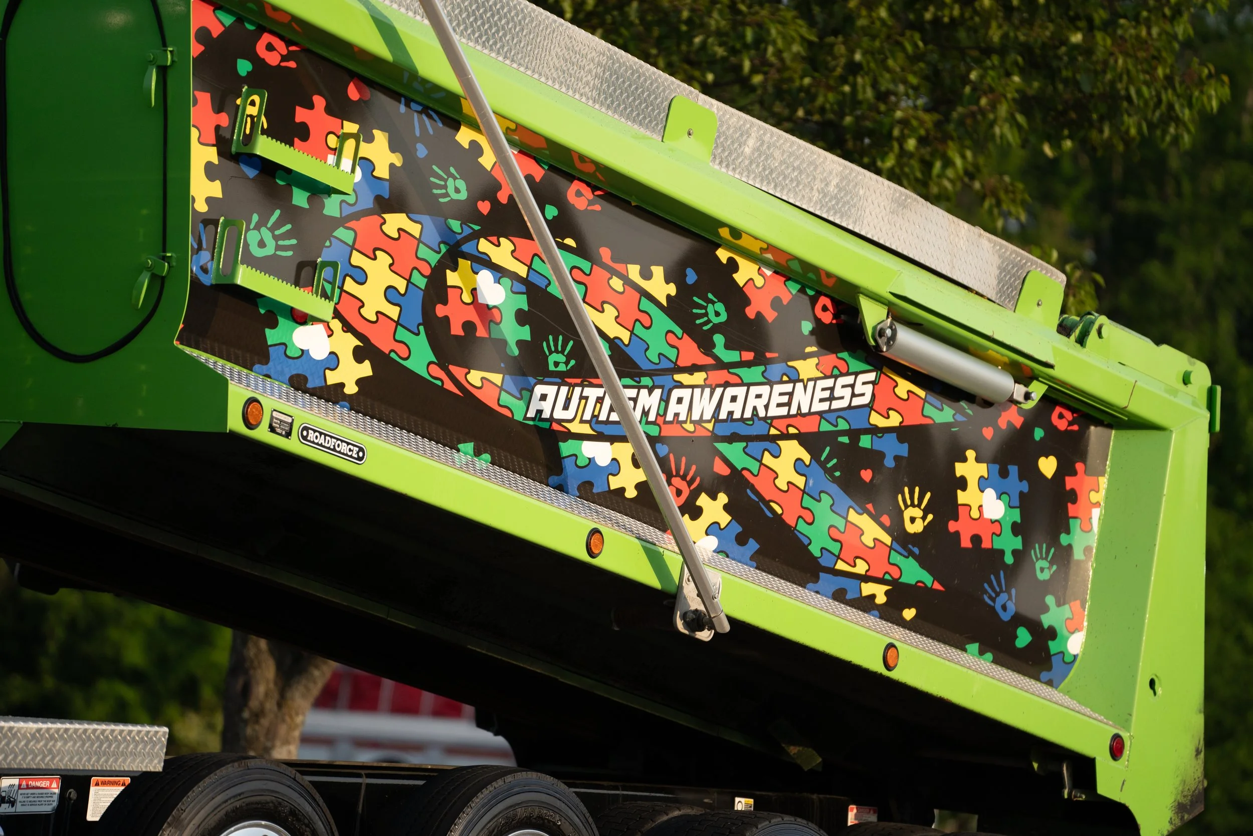 A vehicle with colorful puzzle piece graphics and the words "Autism Awareness" displayed on the side.