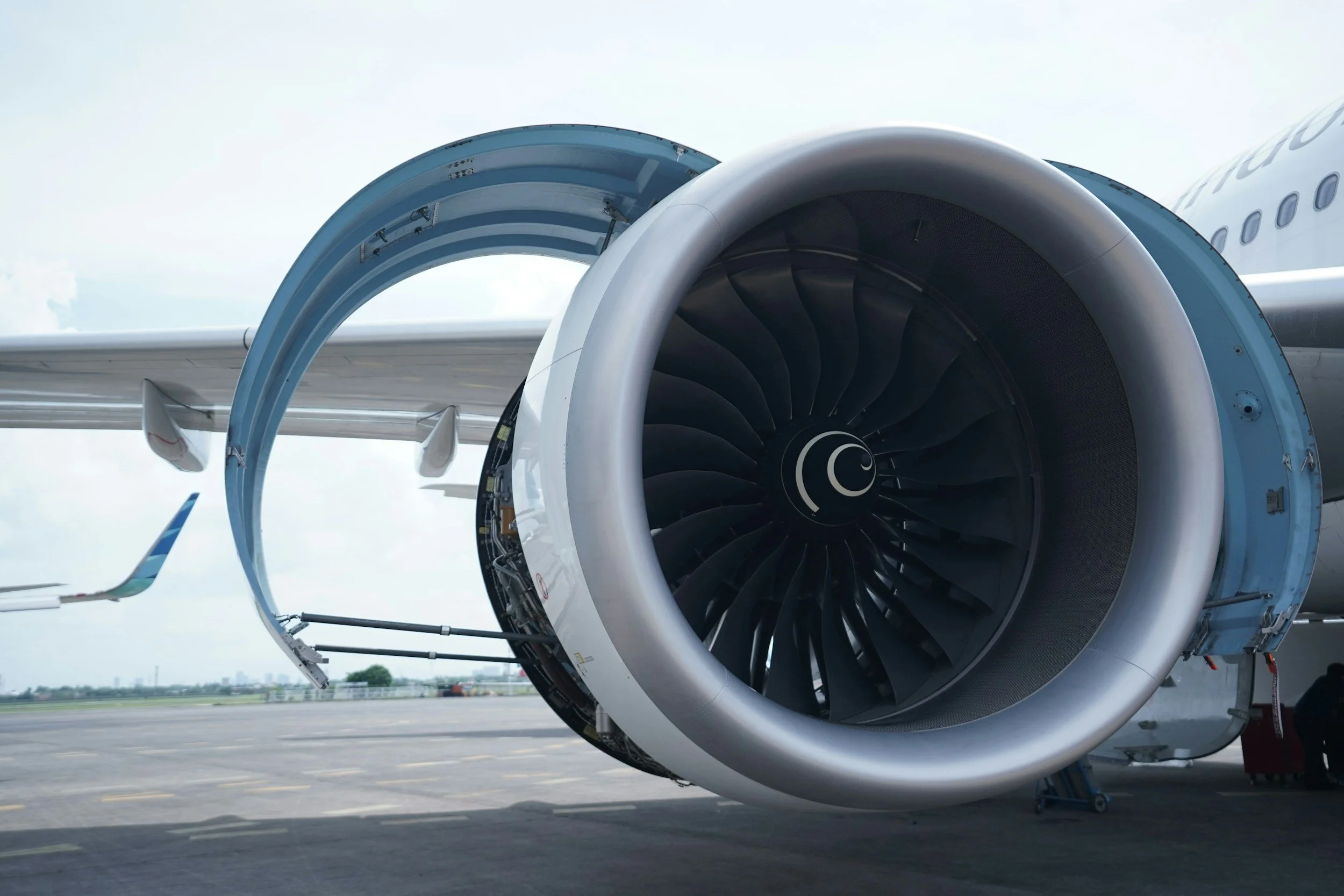 Un moteur d'avion à réaction avec une porte ouverte, situé sur un tarmac de l'aéroport.