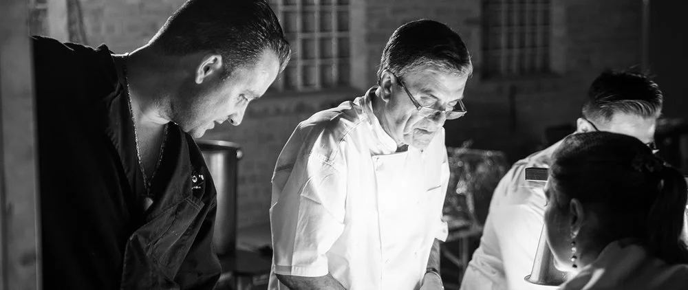 Chef Joey Group of people working together in a kitchen, focusing on a Chef Tomaso.