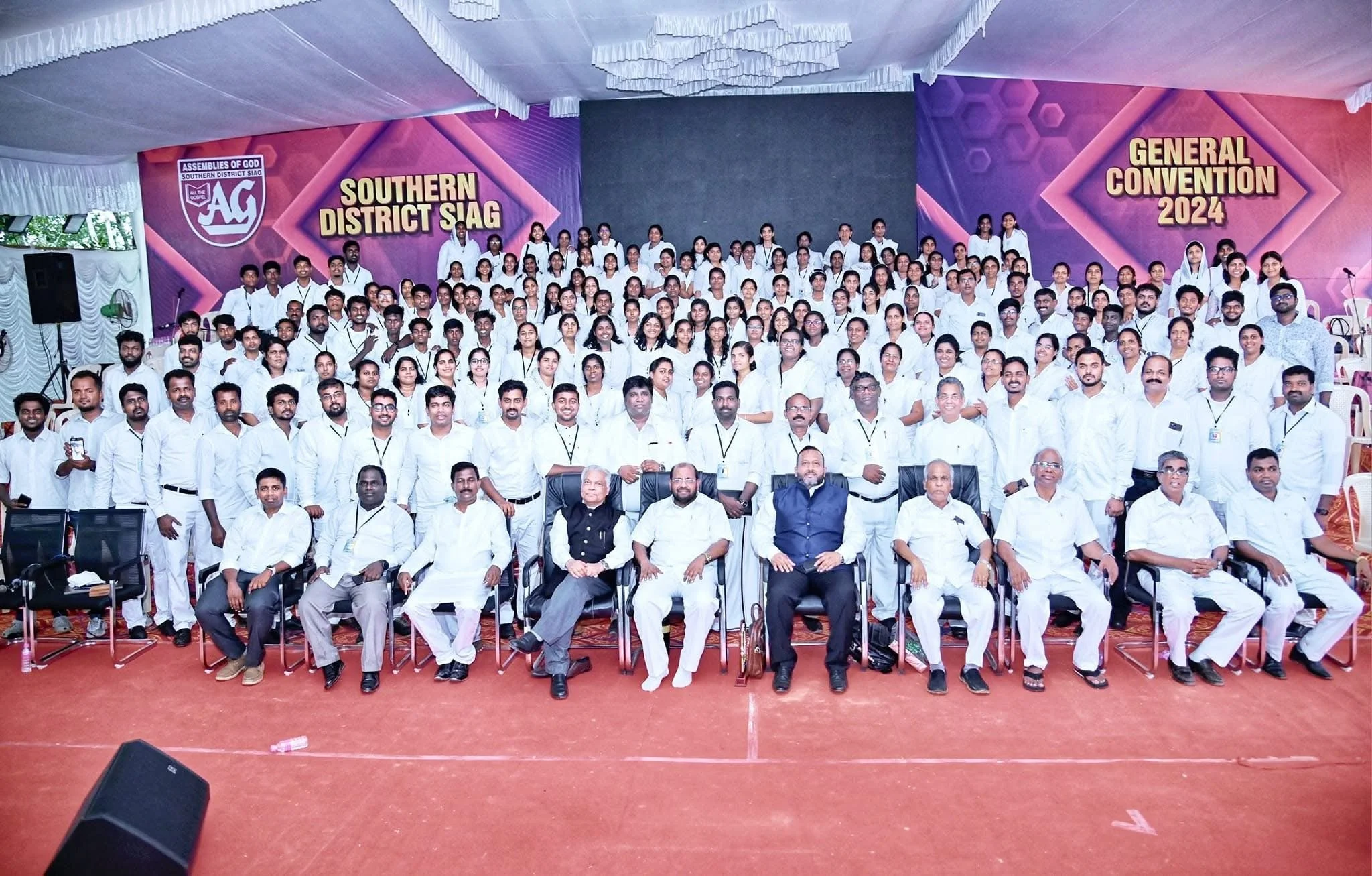 Group photo of many people posing on stage at a convention with banners reading 'Southern District SAG' and 'General Convention 2024'.