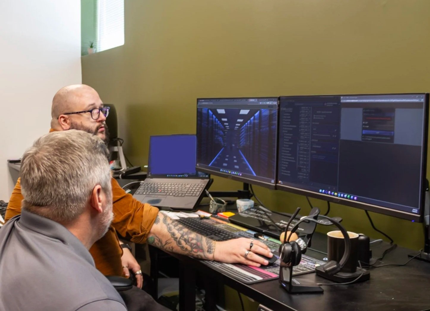 Photo of two people meeting in front of a computer working on IT projects at Purpose Technology Group