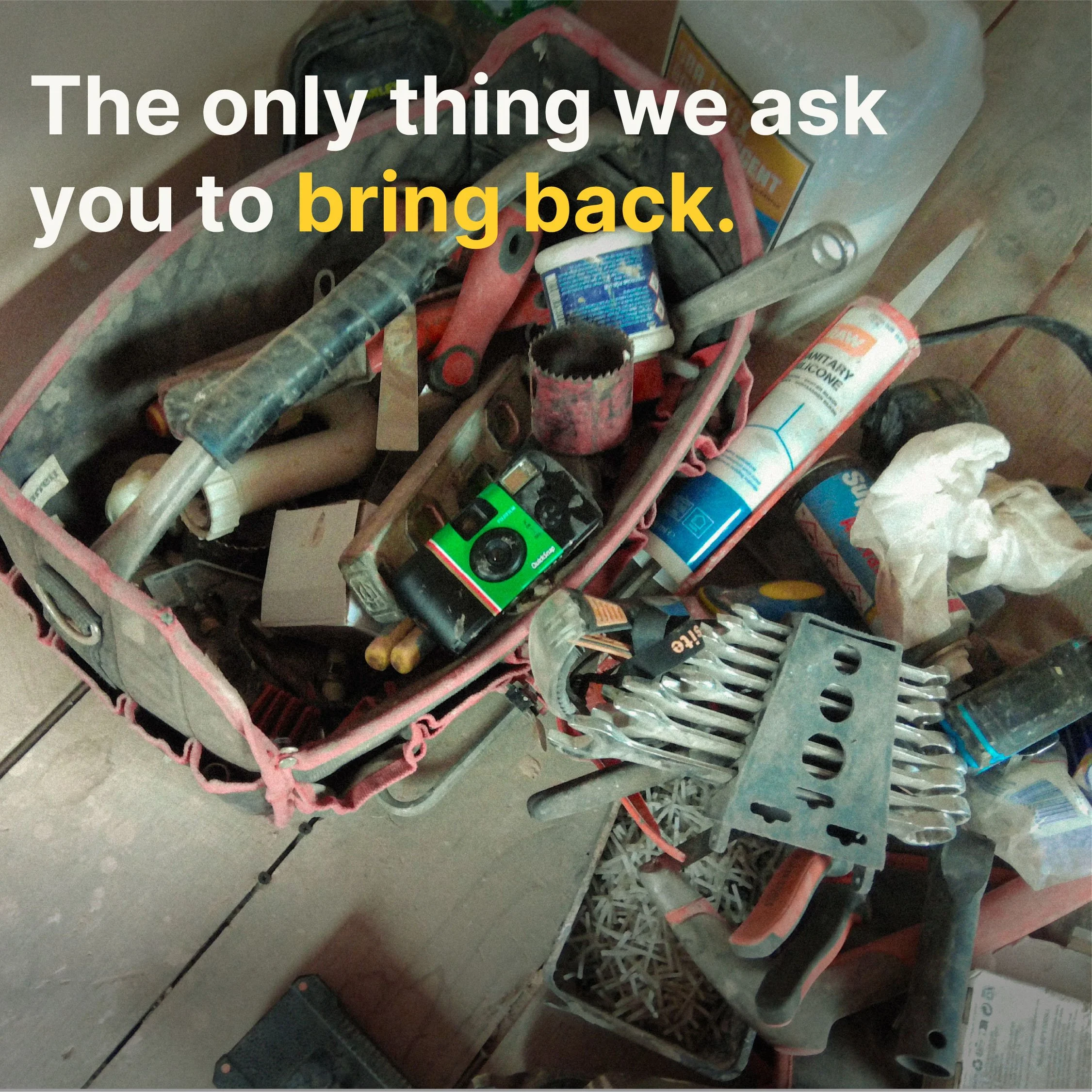A cluttered workbench or table with various tools and items, including a power drill, paint container, and box of screws, with a pink and gray toolbox or organizer.