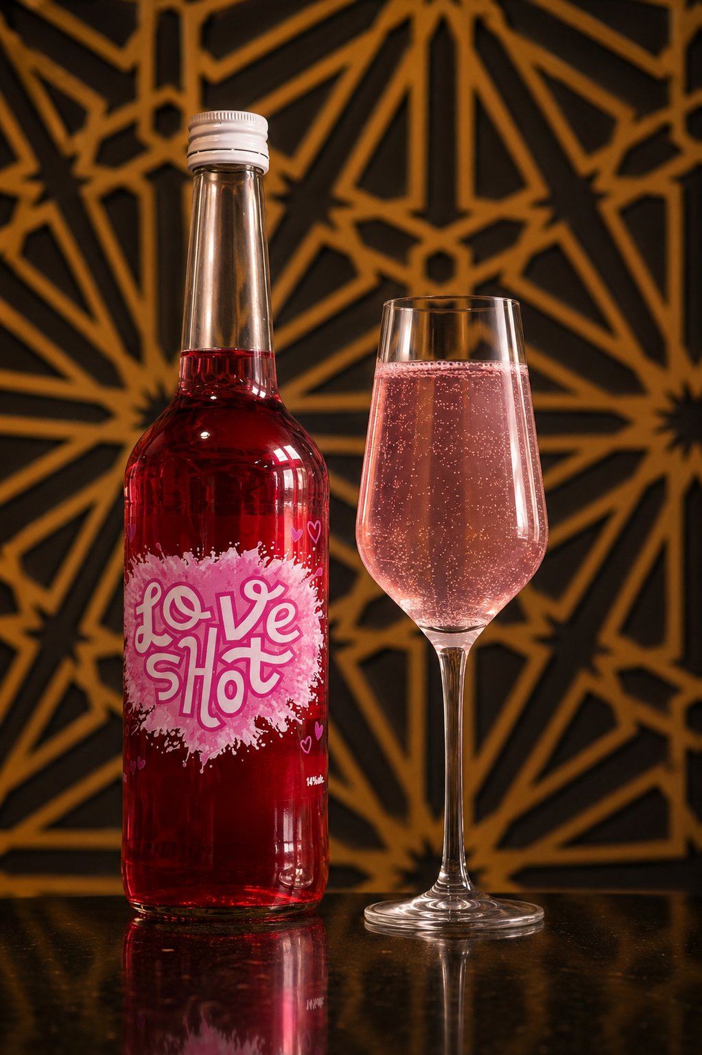 Een fles met een roze drankje en een glas met een vergelijkbaar roze schuimend drankje staan op een zwarte tafel voor een decoratief achtergrondpatroon.