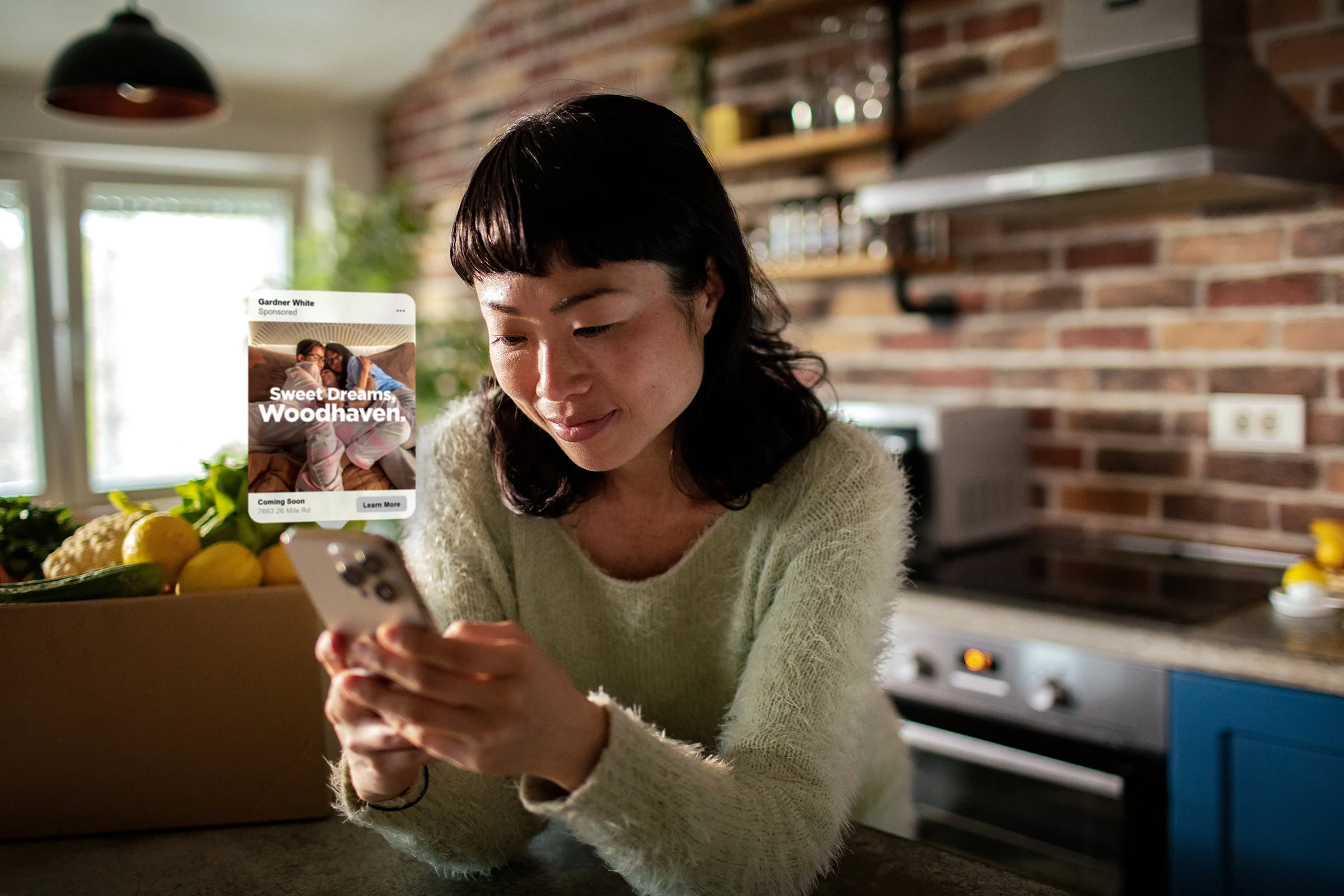 A woman looking at her phone with a social advertisement popping out of it.