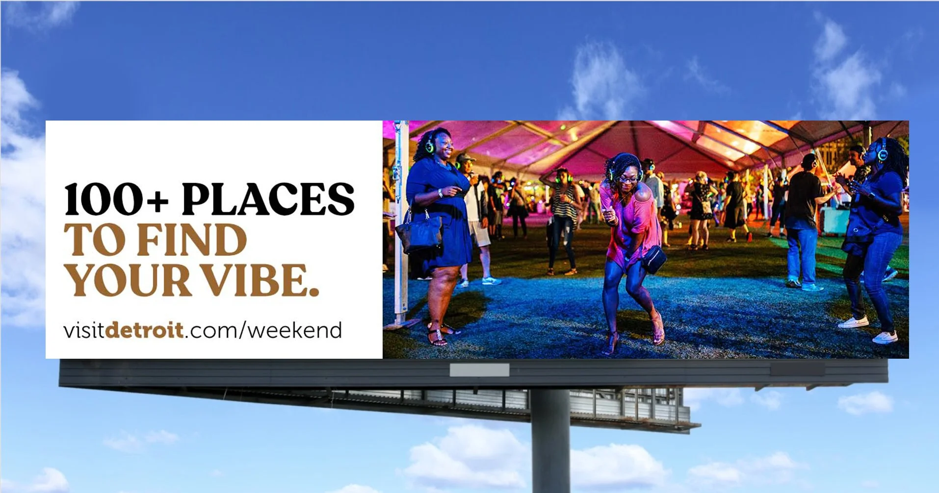 A Visit Detroit billboard with headline, "100+ Places to find your vibe. visitdetroit.com/weekend"