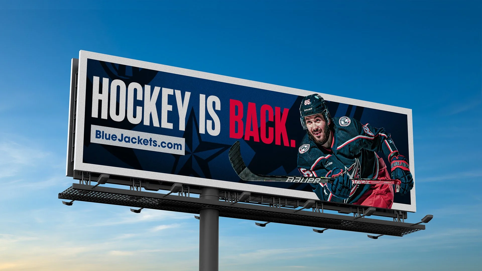 An OOH billboard of a Columbus Blue Jackets player next to the headline, "Hockey is Back. BlueJackets.com"