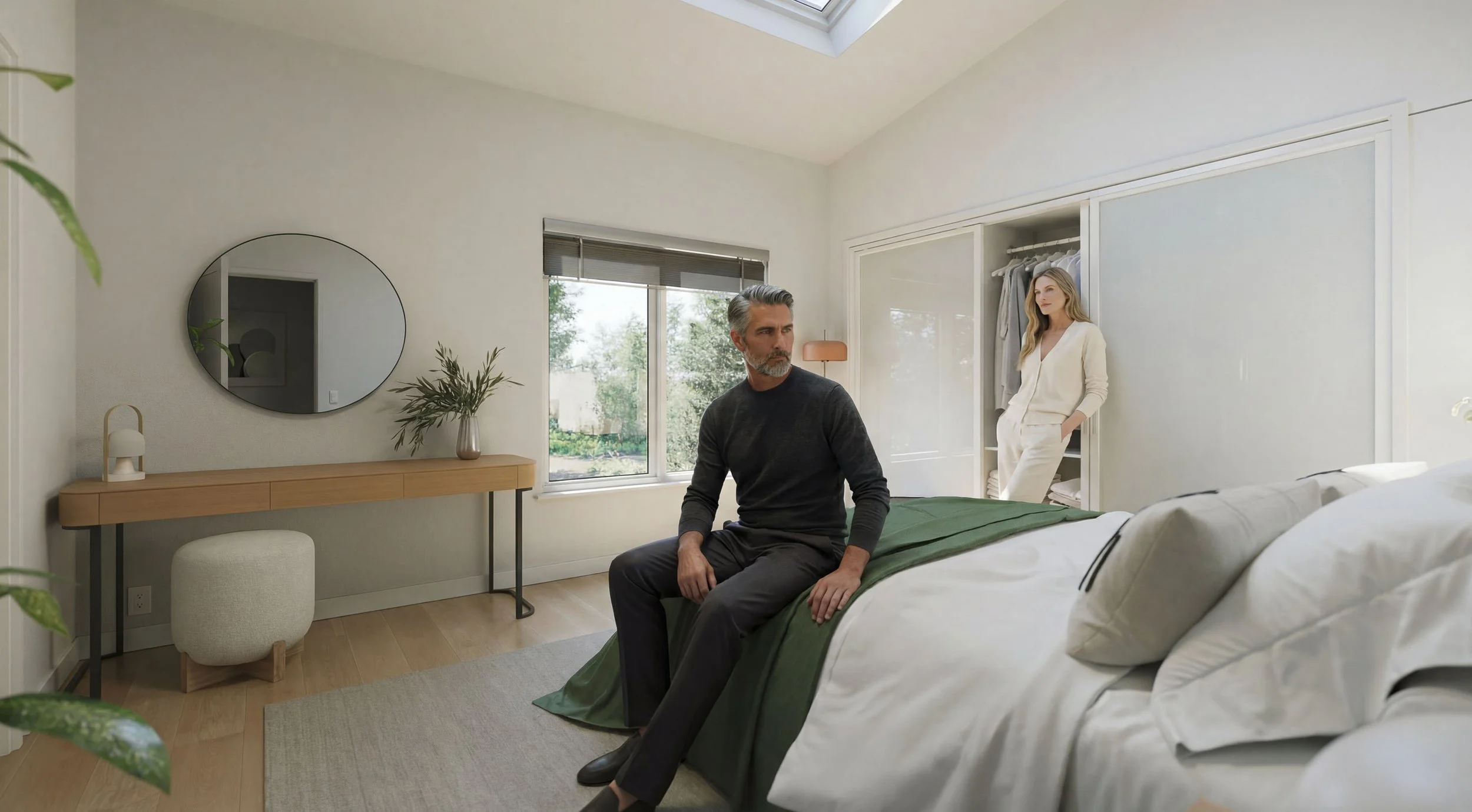 A man sits on a bed in a modern bedroom while a woman stands in the closet nearby. The room has a minimalistic design with a large window, a round mirror on the wall, and decorative plants.