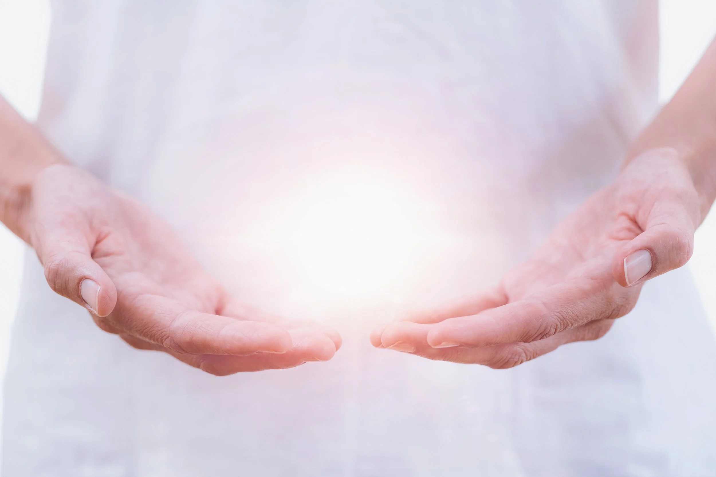 picture of two hands held cupped with a bright white light coming from them