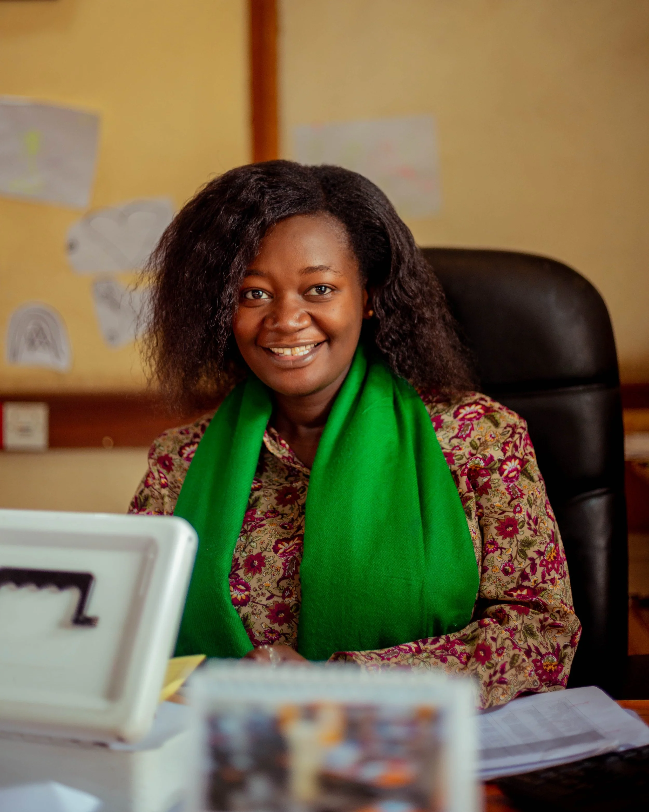 Close-up of a smiling woman with computer and green scarf