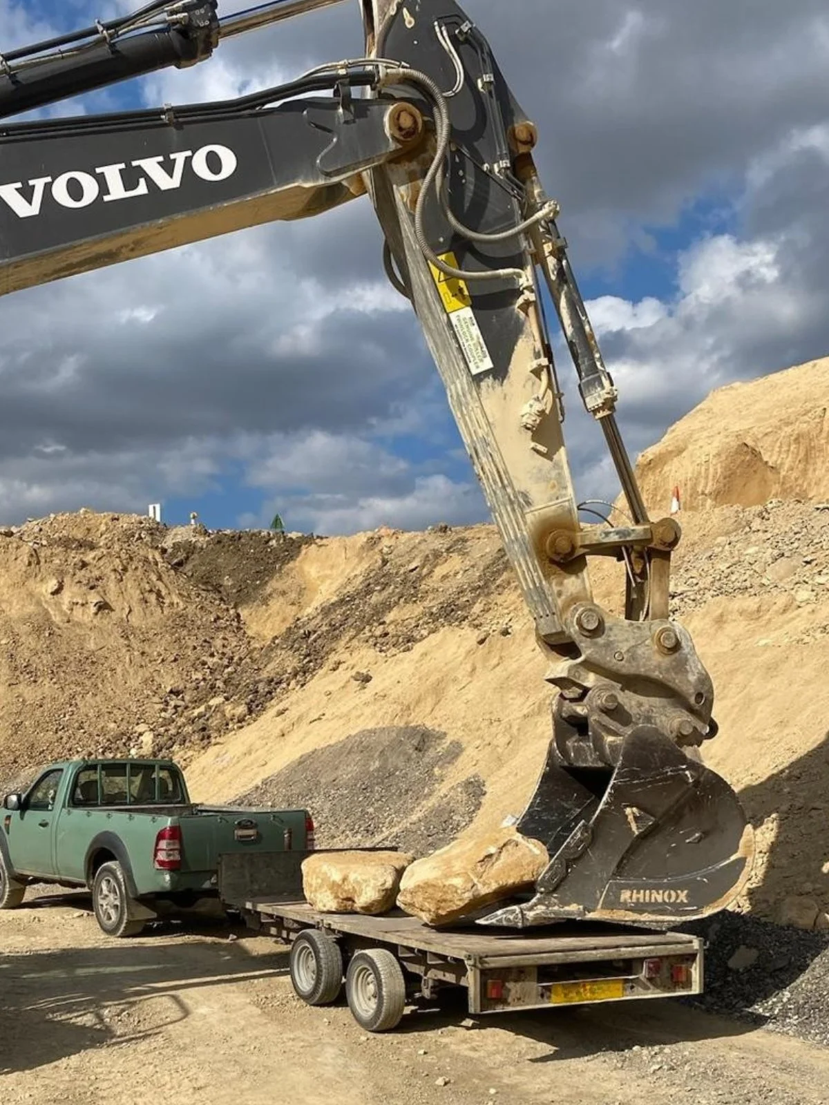A pick up truck with a dumper bucket loading a huge lime stone in an English quarry