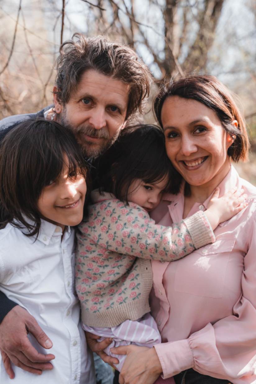 Parents holding their children outdoors, representing the family bonds supported by La Familia Family Services in Newport News, VA