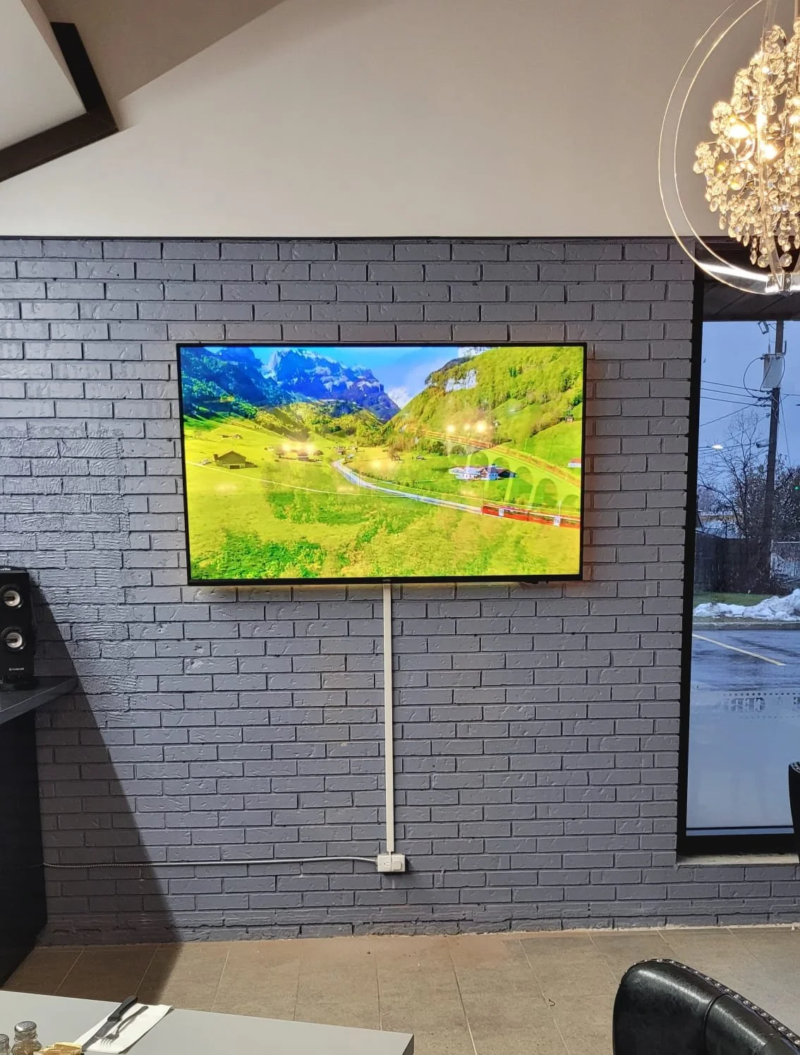 Une télévision affiche une image d'un paysage verdoyant avec des montagnes en arrière-plan.