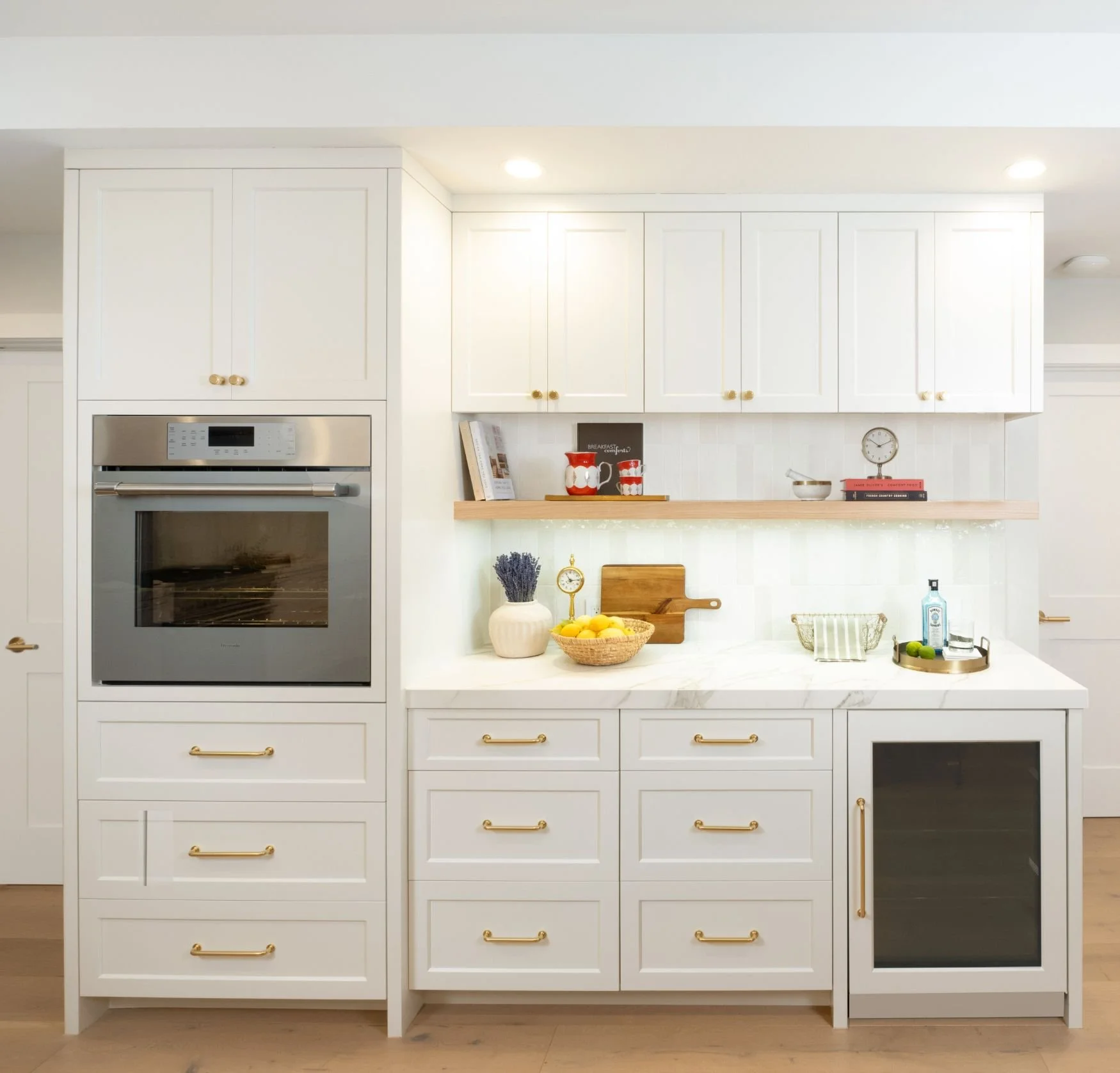 Built-in white cabinets with wine fridge and floating shelves