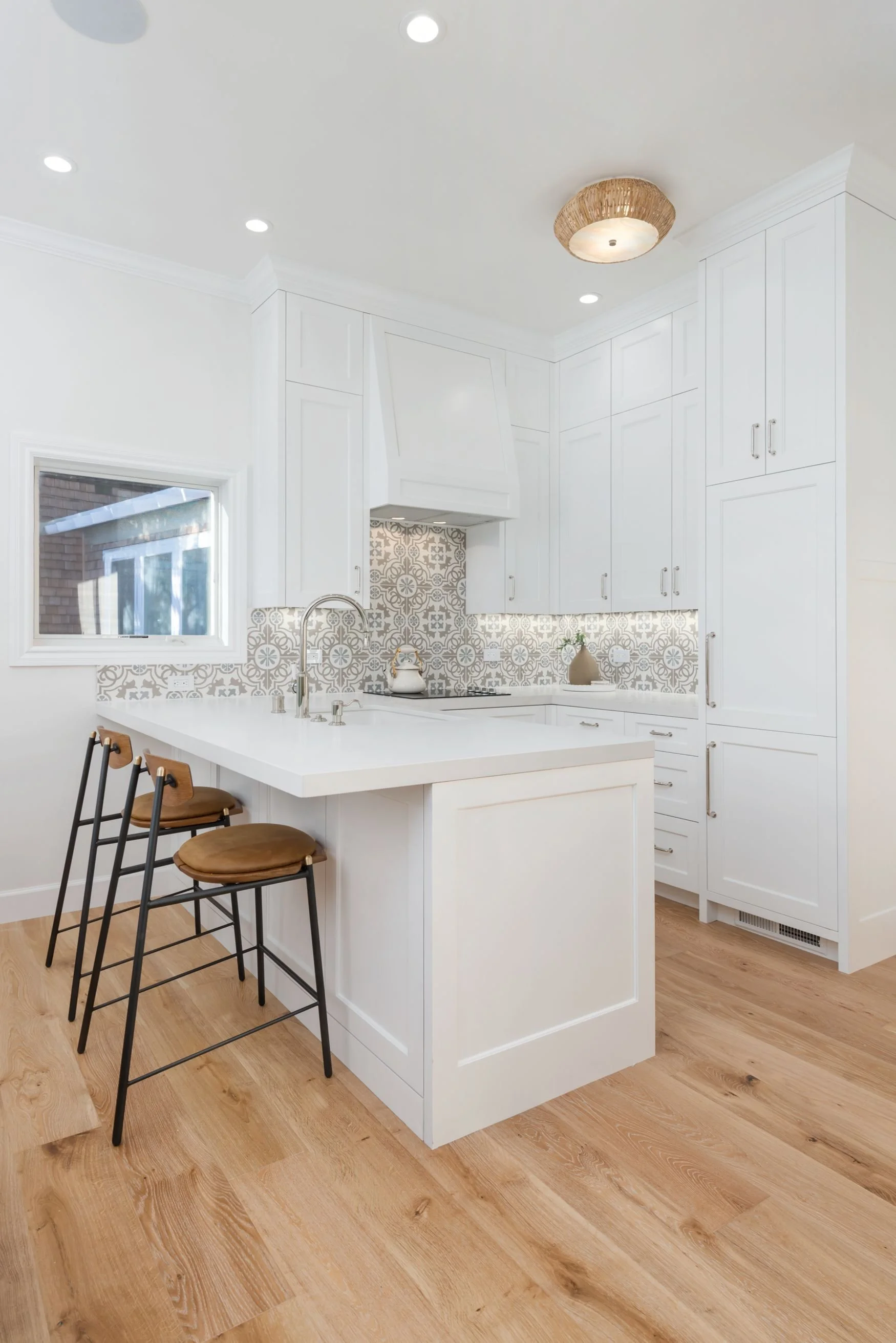 ADU kitchen with white cabinets and oak flooring