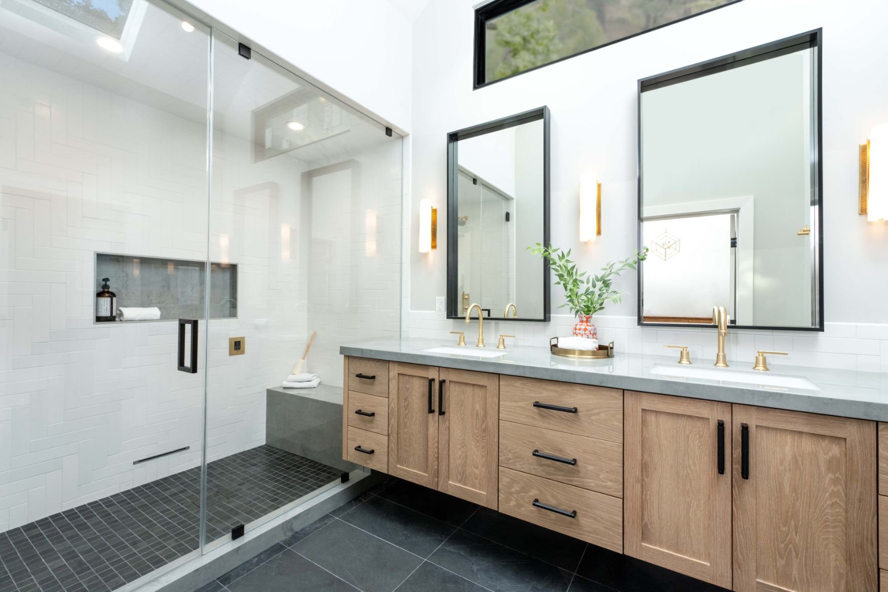 Custom double sink vanity with light oak stain, black mirrors and slate floor tile, large walk in shower