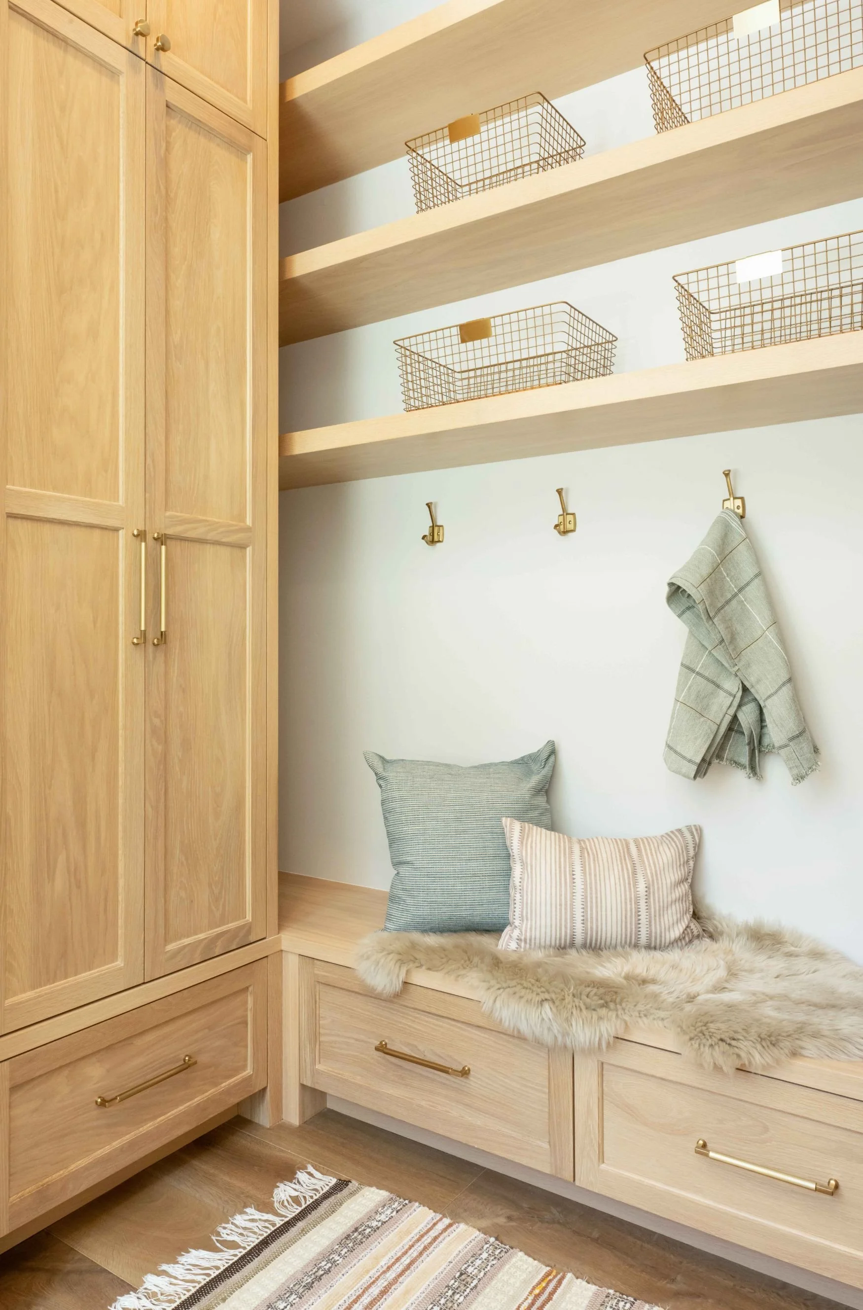Mudroom cabinets with oak cabinetry and bench with drawers