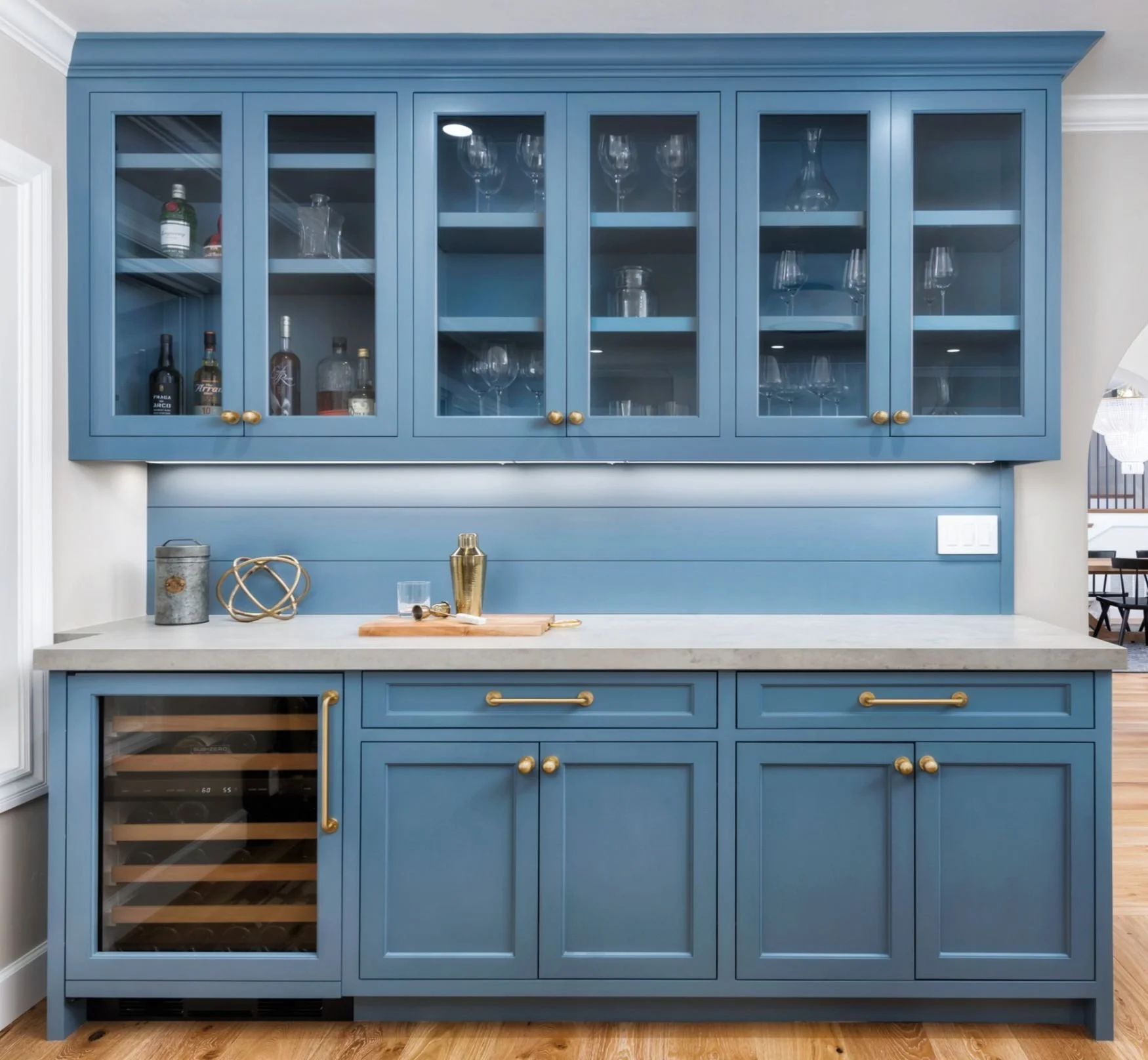 Blue built-in bar with glass front cabinets and wine fridge