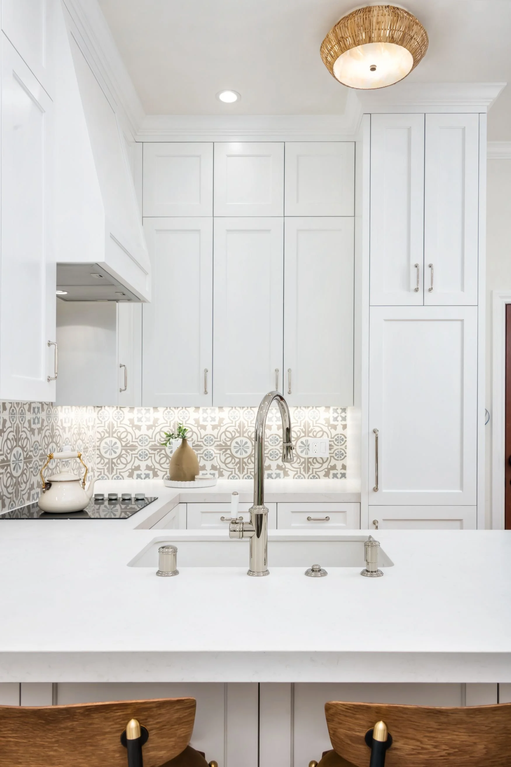 ADU kitchenette with white cabinets and countertops and decorative tile