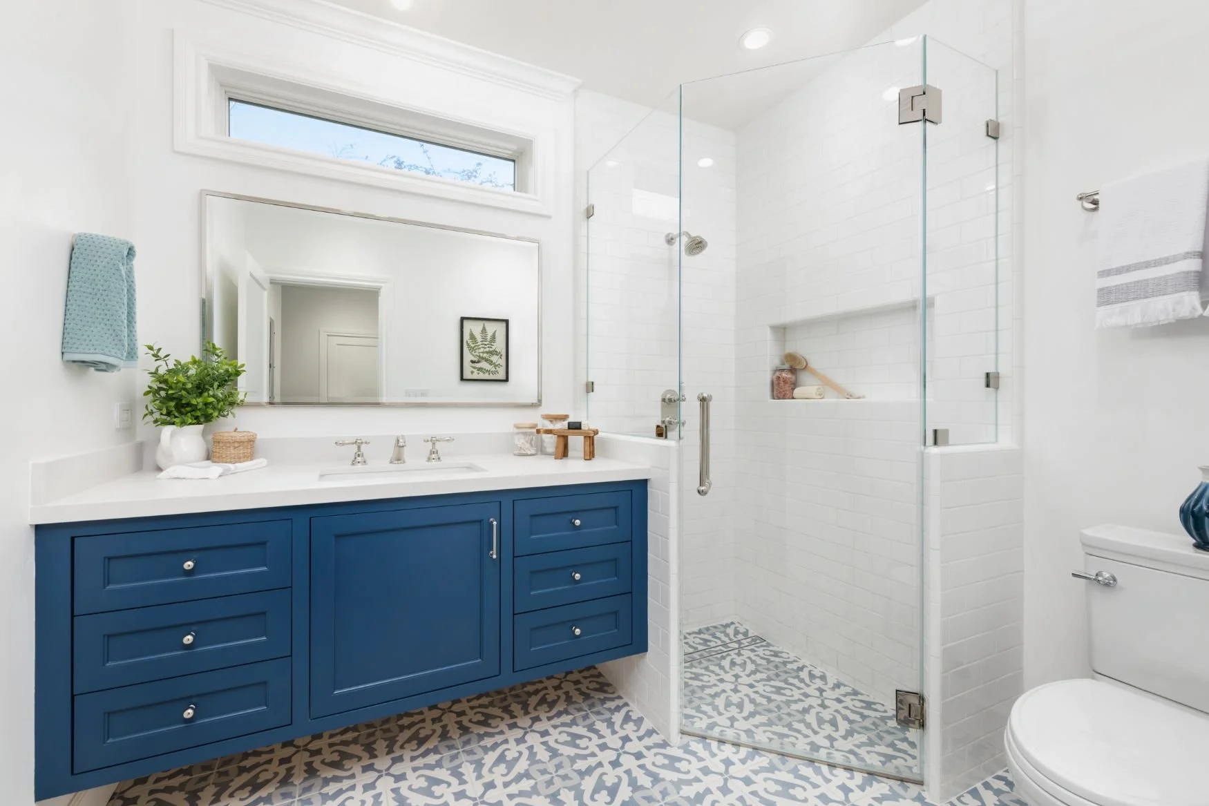 Corner shower with white subway tile and pattern blue floor