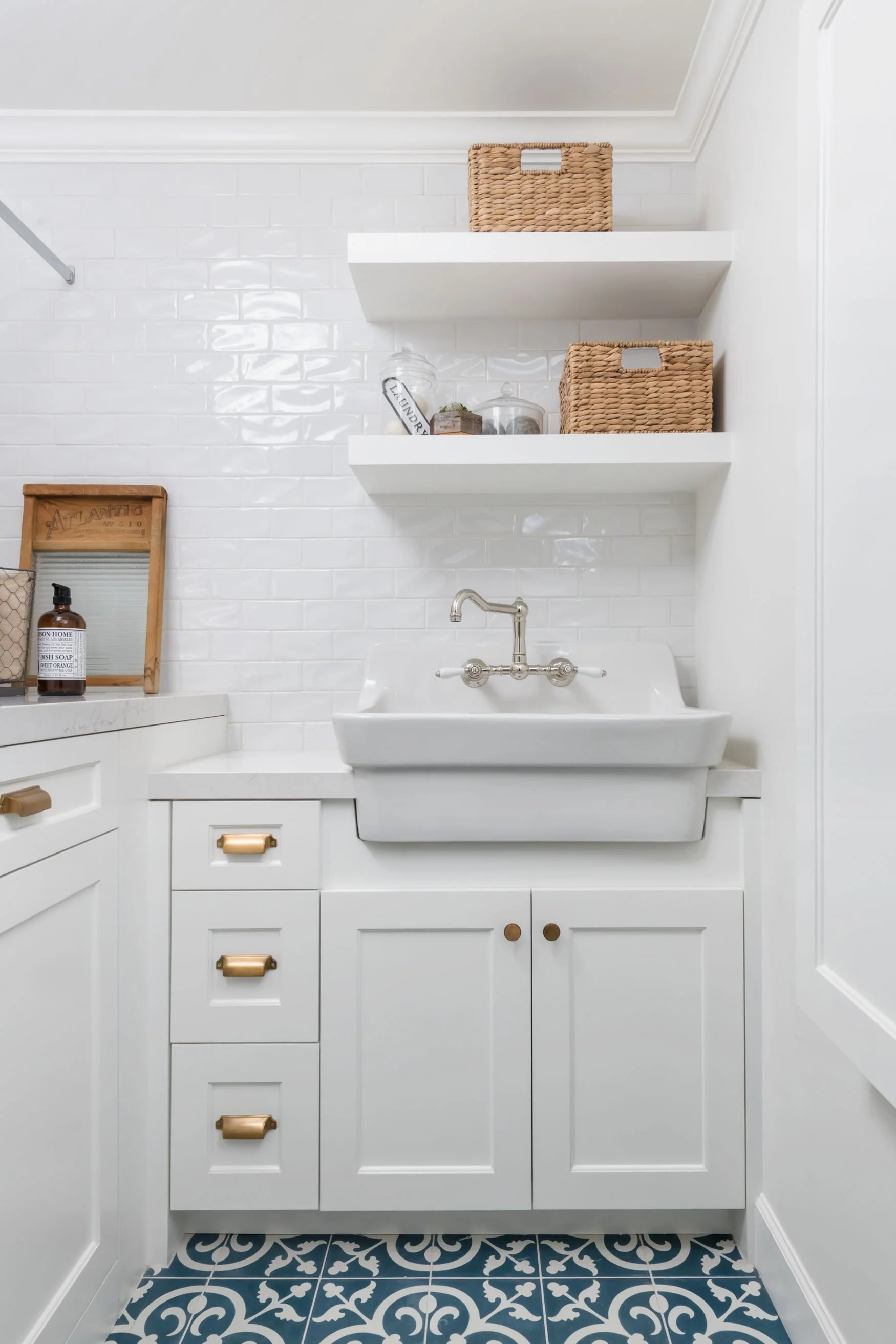 Farmhouse laundry sink with white floating shelves