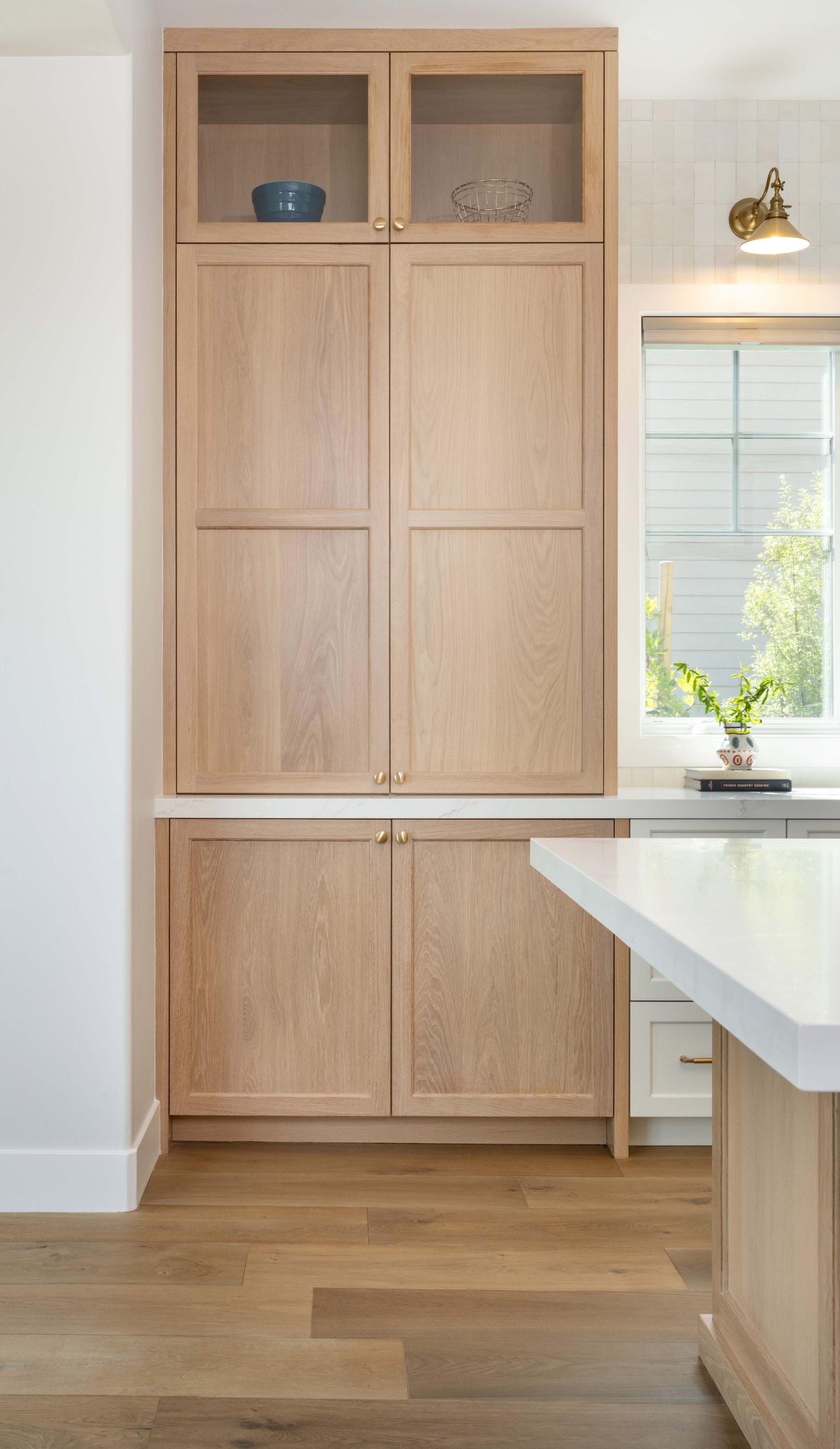Closed pantry cabinet storage with white oak cabinets and flooring