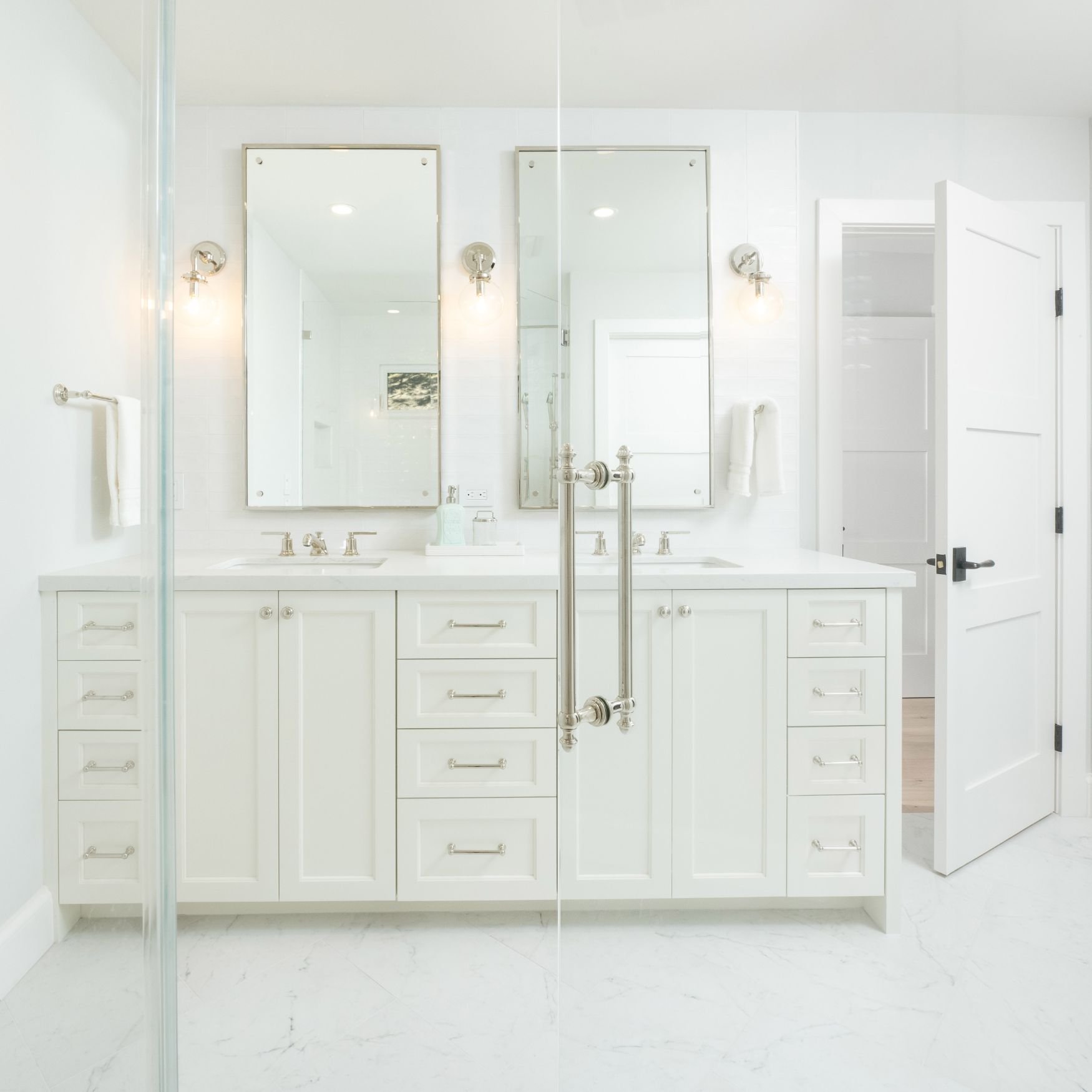 Bathroom with white double sink vanity, polished nickel mirrors and hardware and white tile