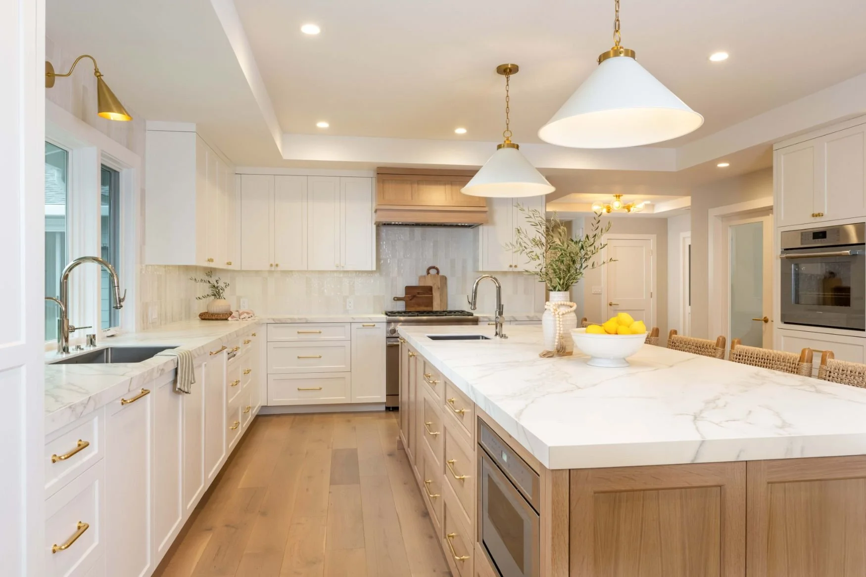 Bright kitchen with marble countertops and white and brass fixtures