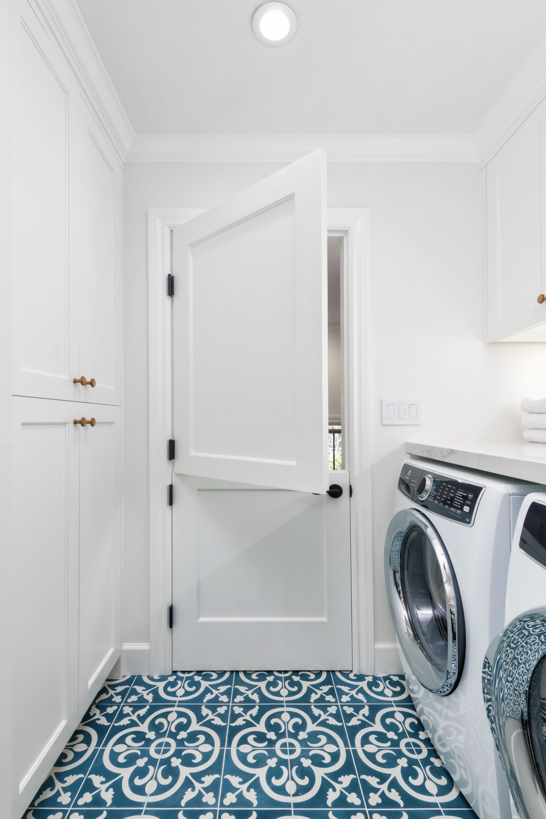 Dutch door in laundry room with blue cement tile floor