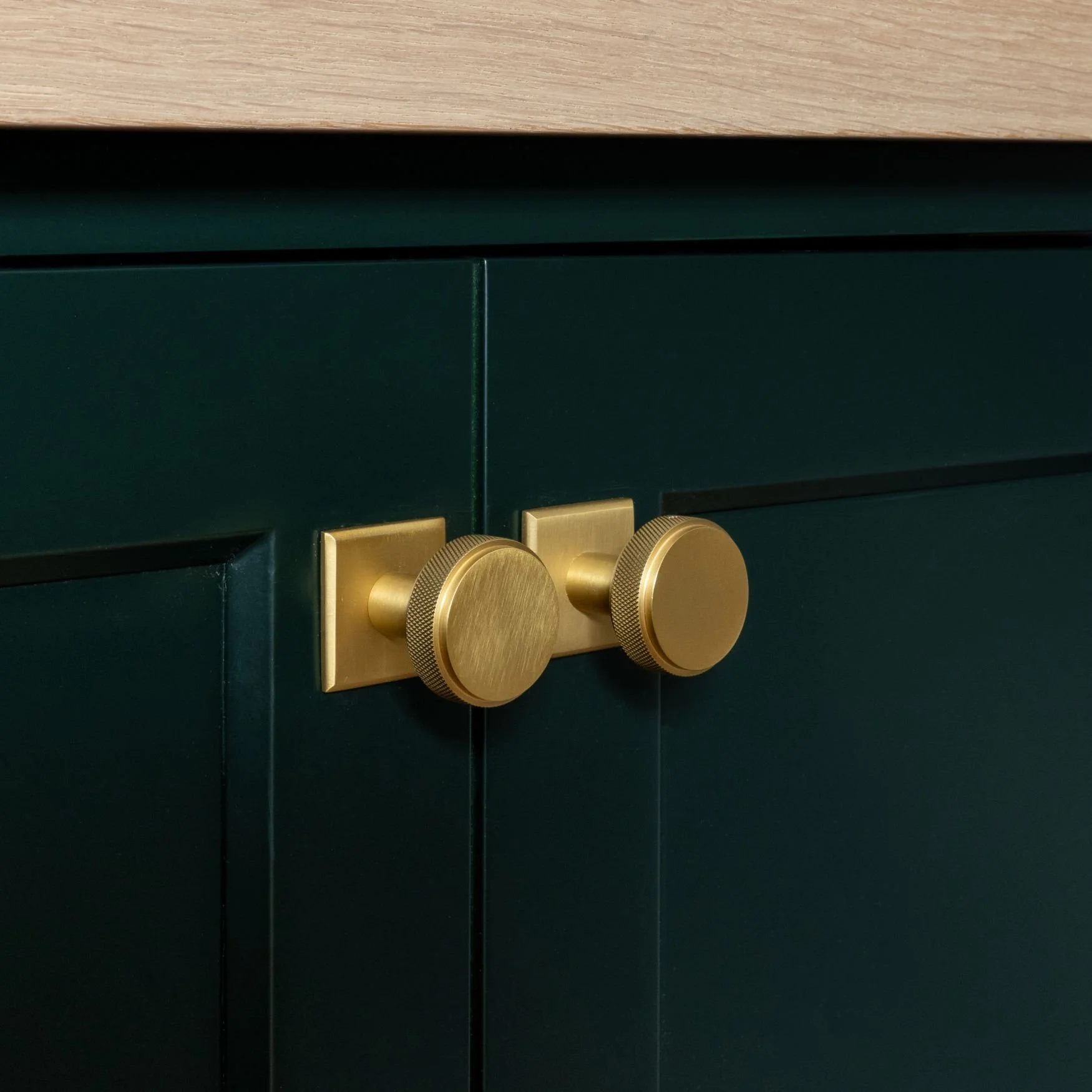 Brass hardware on green cabinets