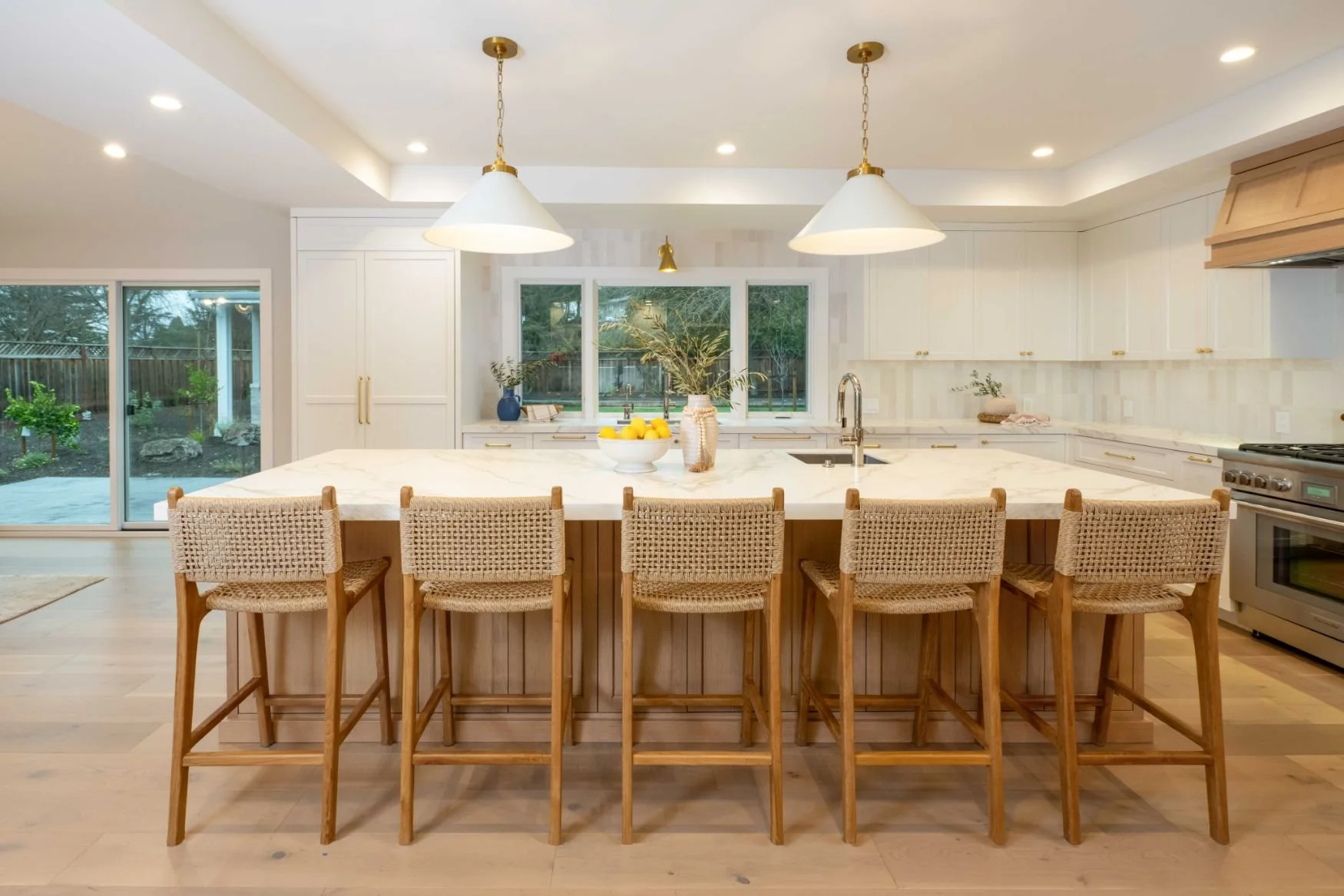 white oak island with room for 5, oak flooring and white cabinets