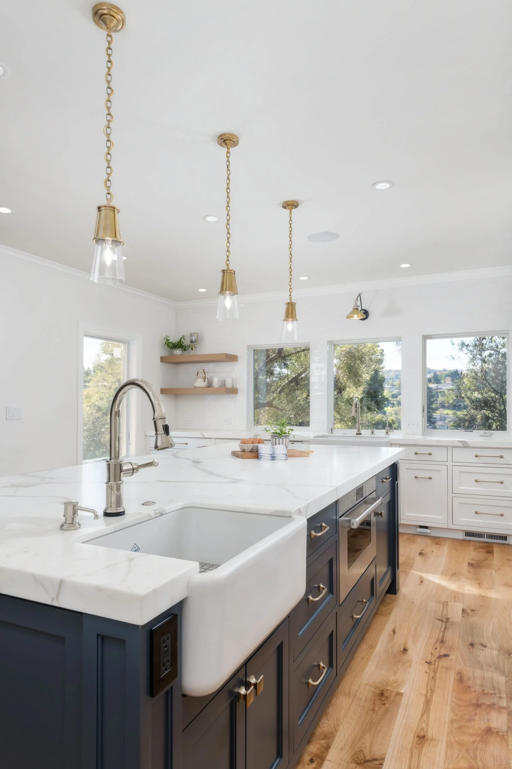 Two tone kitchen island with brass lighting