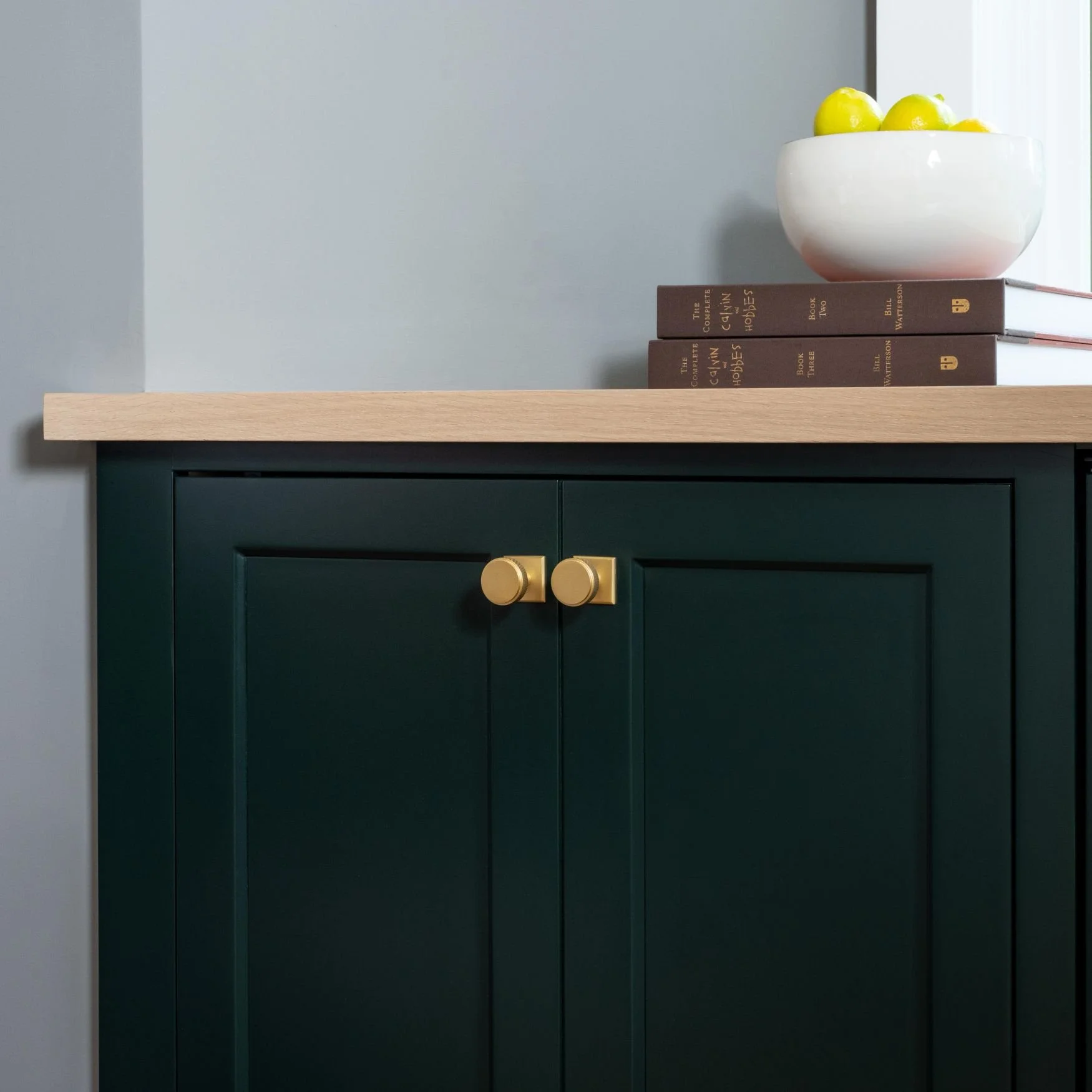 Green cabinet detail with brass cabinet hardare