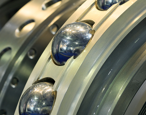 Close-up of a ball bearing with a metallic outer ring and shiny steel balls inside.