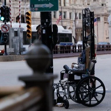 An abandoned wheelchair with accessories and other items. This wheelchair was unoccupied. Unsure of the location of the owner. 
Maybe it's just a prop.