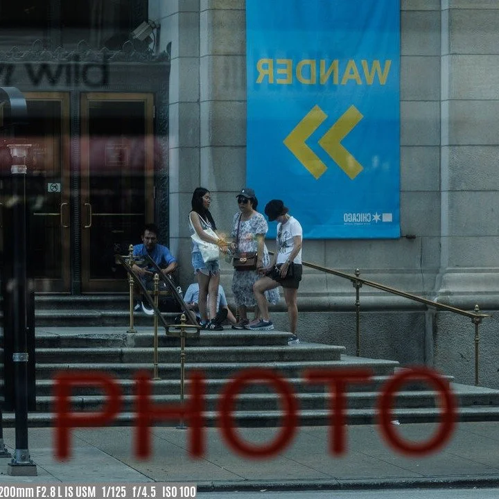 The store window acted as a mirror, and the lettering gave me the idea to frame this shot. The people were standing on the steps of the Chicago Cultural Center across the street from the window. My intent was to use the &ldquo;PHOTO&rdquo; lettering 
